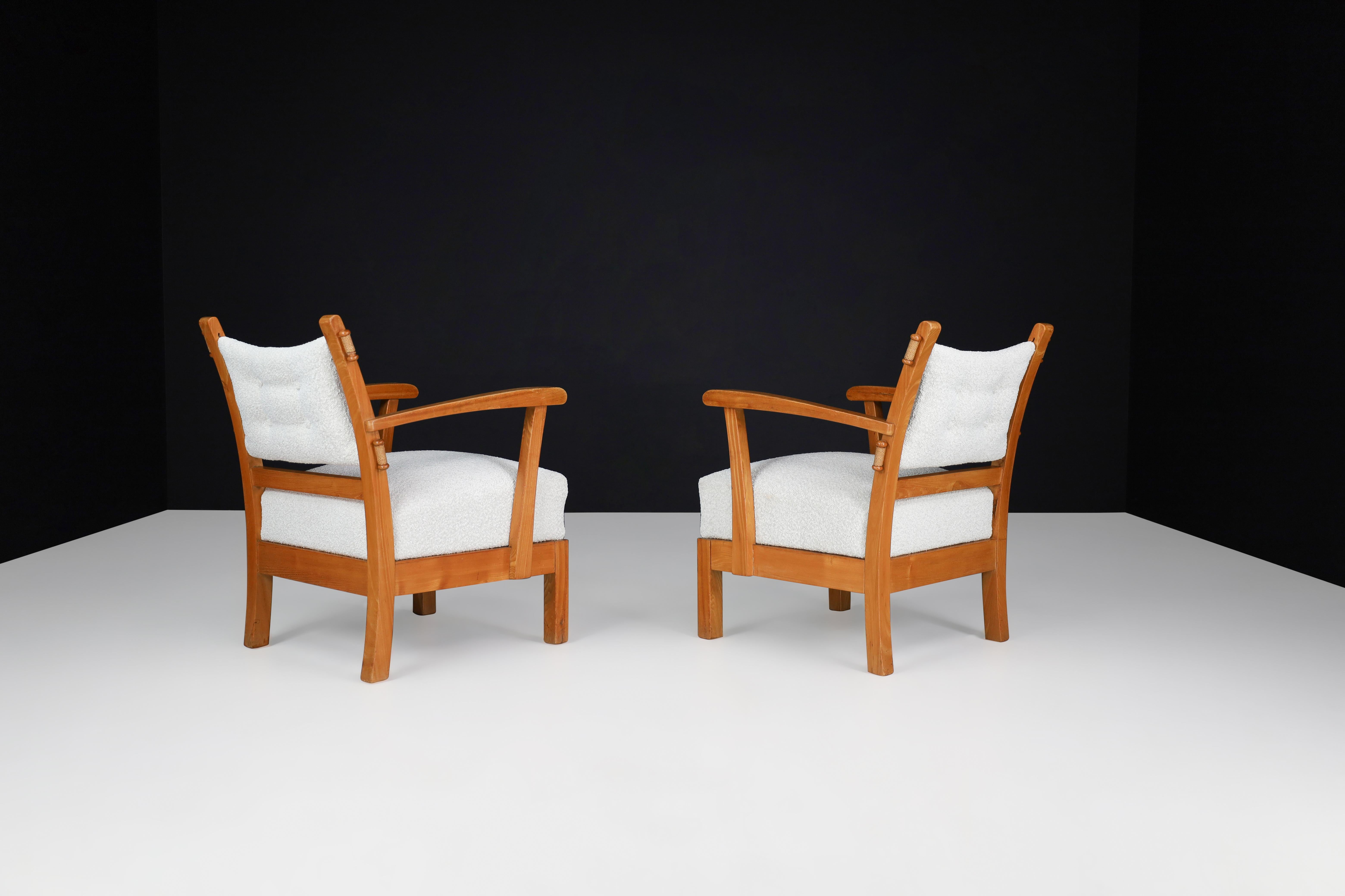 Reupholstered Lounge chairs with sculptural Elm wooden frame France, 1950s.

Set of two lounge chairs in solid elm and Reupholstered bouclé fabric, France, 1950s. The wood grain is nicely visible, especially on the sculpted armrests. These
