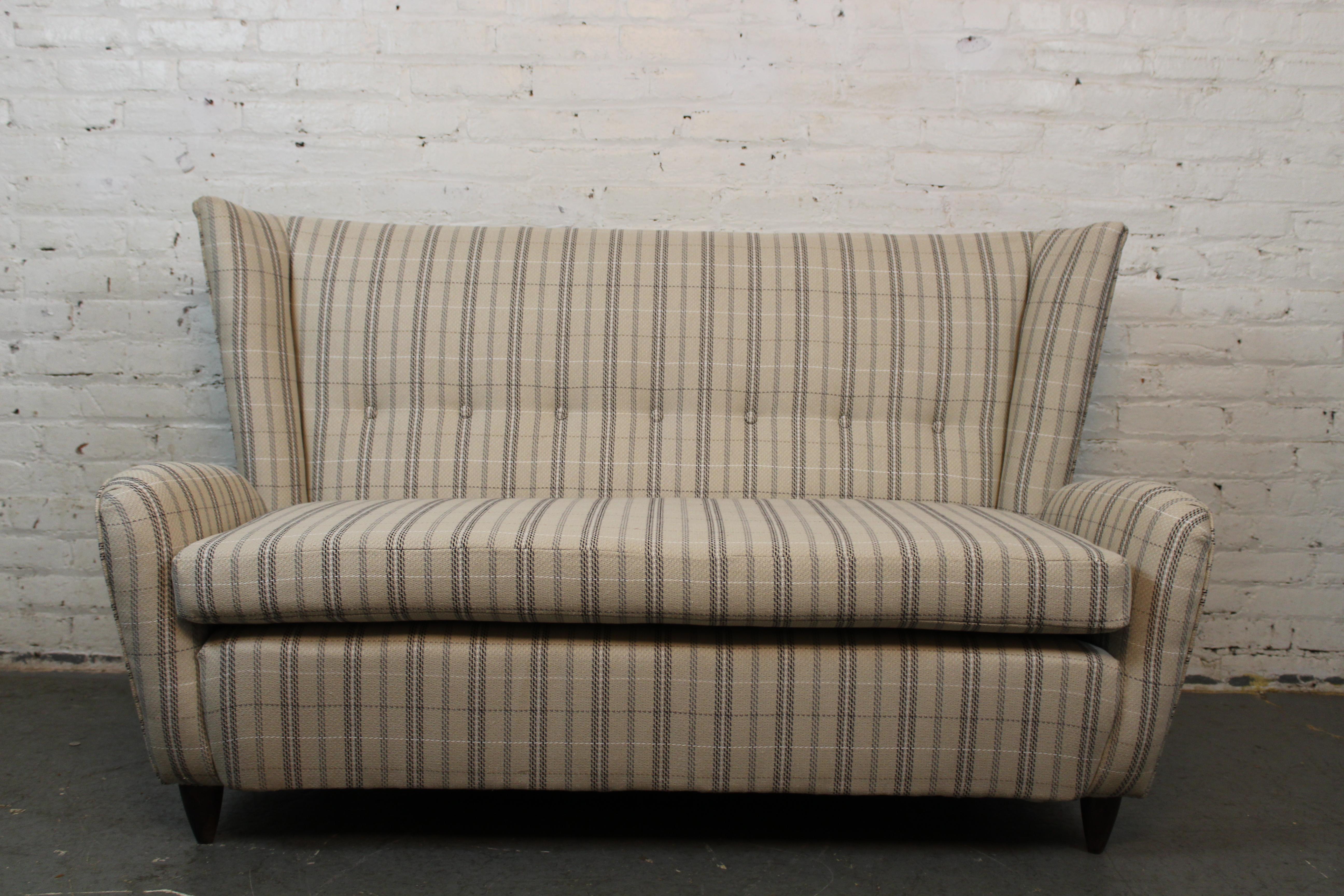 Lassen Sie sich von der wunderschönen Einzigartigkeit der legendären italienischen Designerin Paola Buffa mit diesem fantastischen, zierlichen Wingback-Sofa begeistern. Dieser charmante Sitz aus den 1950er Jahren schlägt mit seinen übertrieben