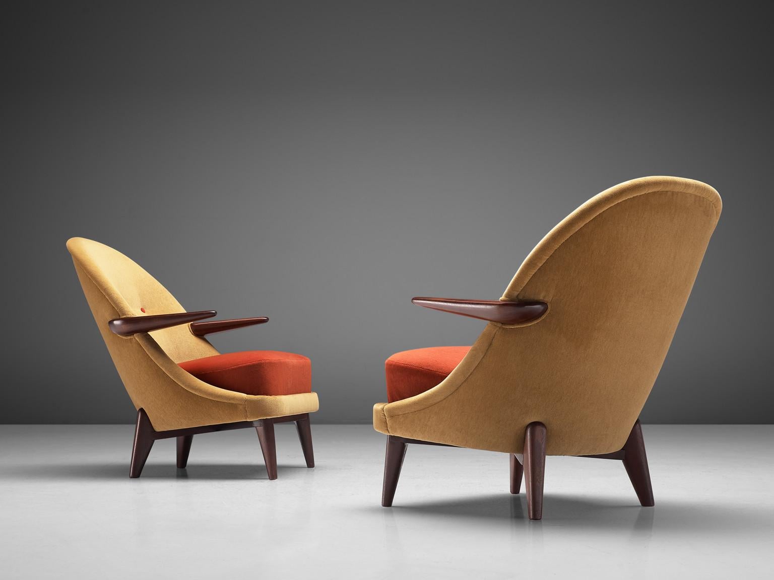Pair of lounge chair, wood, velvet, Denmark, 1950s

These 1950s Danish modern chairs present a form that feels simultaneously grounded and buoyant. The backrests curve in a continuous, generous arc, cradling the sitter. The tapering, splayed legs,