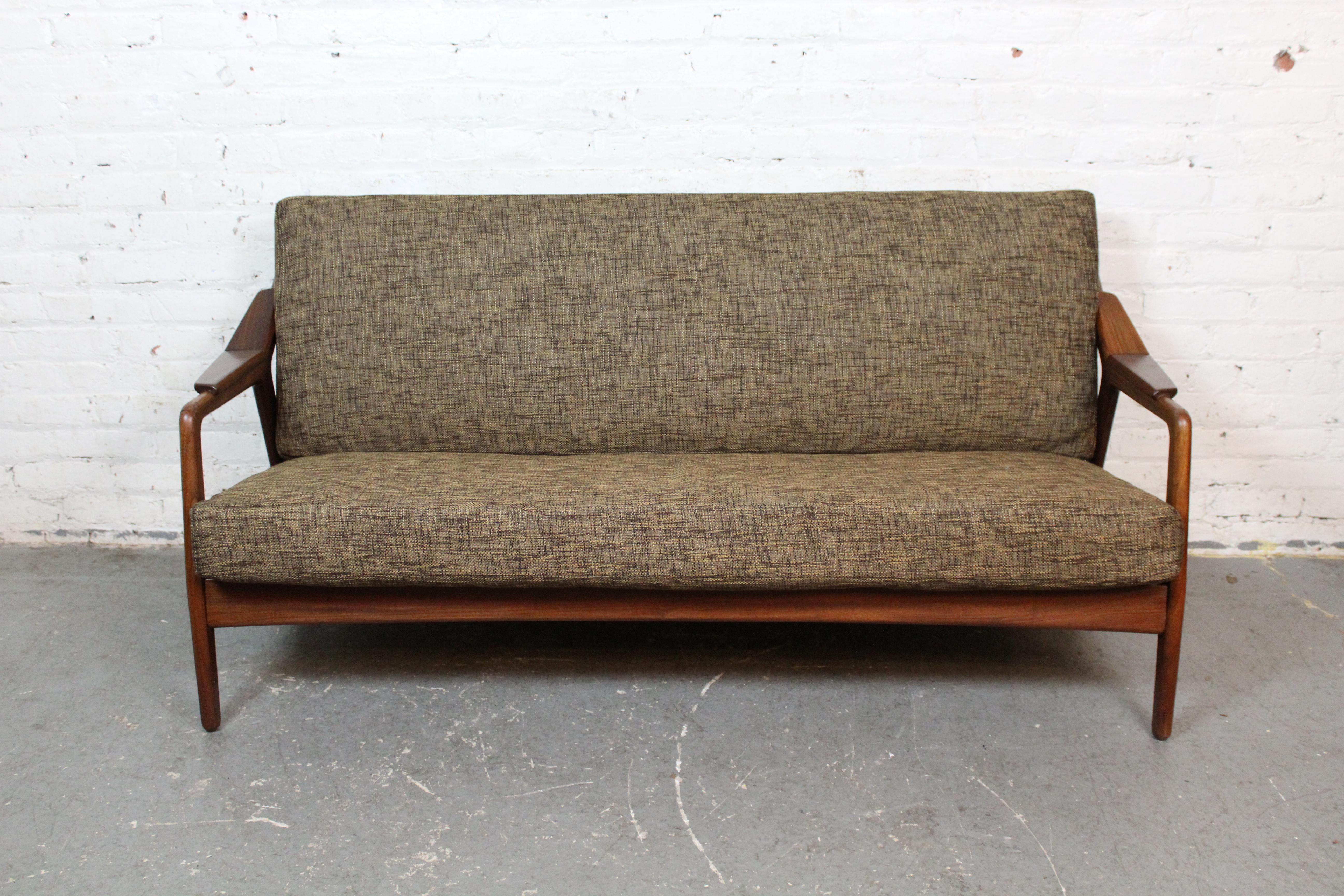 Blurring the lines between furniture and sculpture, this exceptional carved walnut sofa exemplifies classic mid-century Scandinavian craftsmanship. Designed by H. Brockmann Petersen for Randers Møbelfabrik of Denmark, the Boomerang-style arm rests