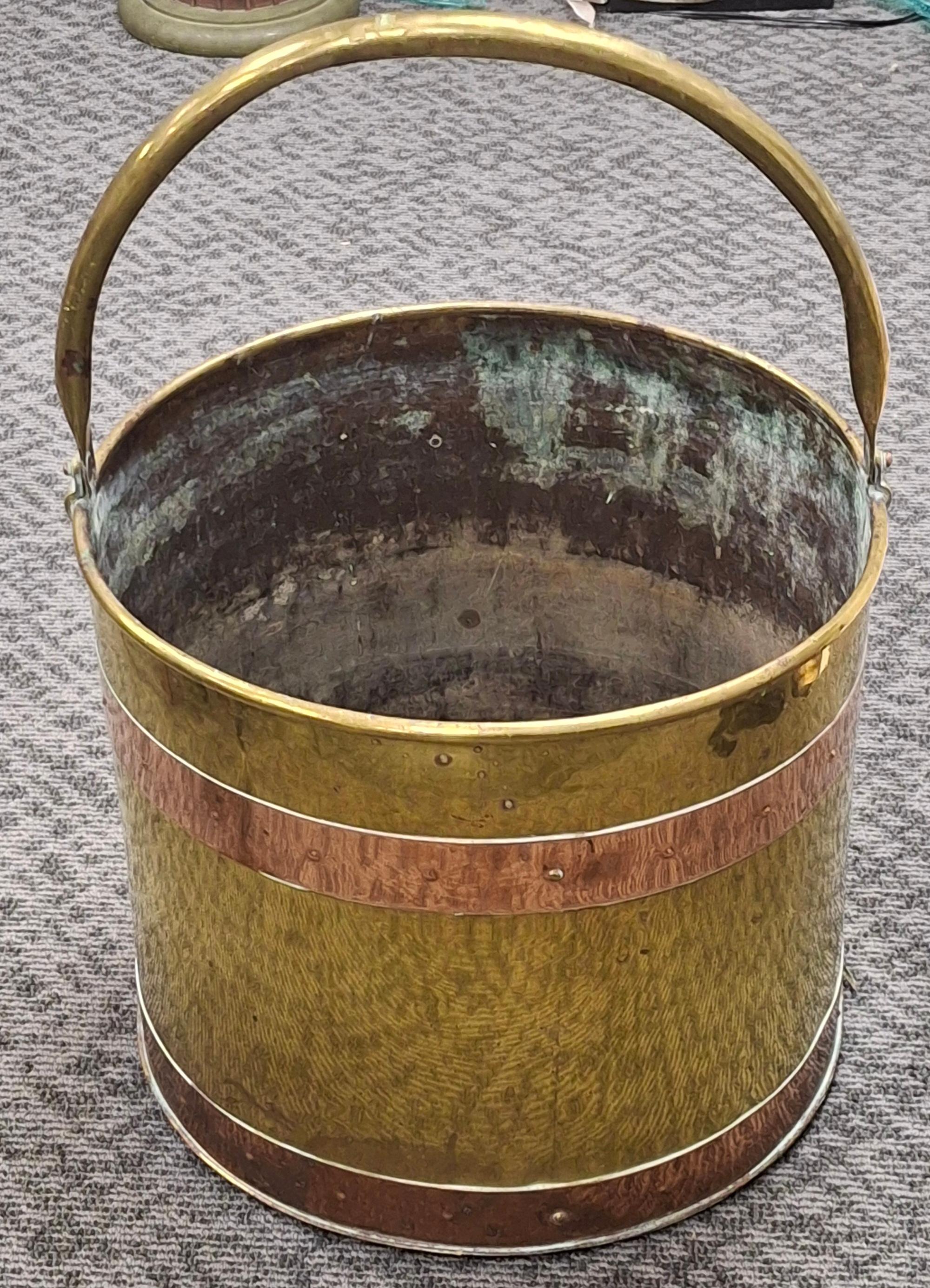 Ein amerikanischer handgefertigter Eimer aus poliertem Messing und Kupfer des 20. Jahrhunderts von Revere Copper and Brass Co.
Dieser antike Eimer aus Messing und Kupfer, der wahrscheinlich Anfang des 20. Jahrhunderts in England hergestellt wurde,