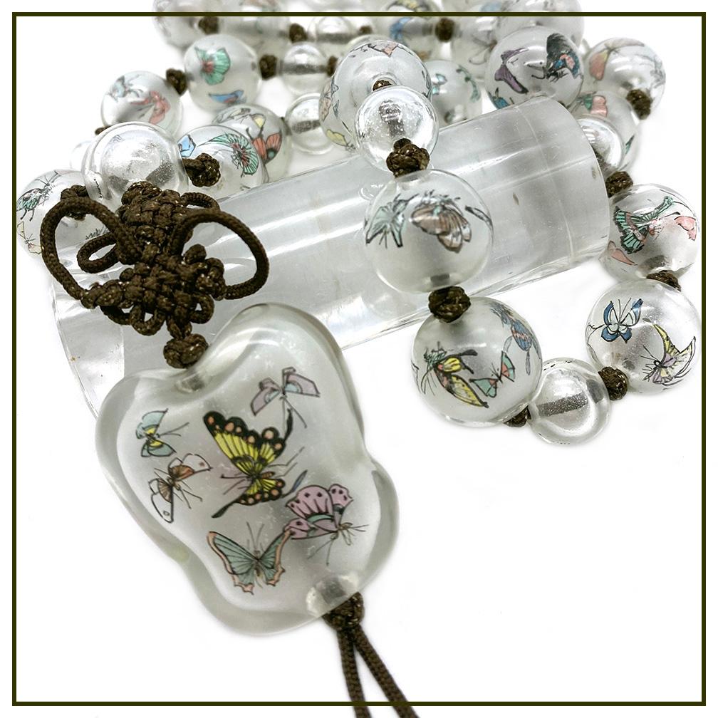 This is a reverse hand painted glass beads necklace. It has silk knotted up to 20mm glass beads with hand painted butterflies plus a banana leaf shaped glass pendant and silk tassel with 6.5 inch drop down.

The Chinese reverse hand painted on glass