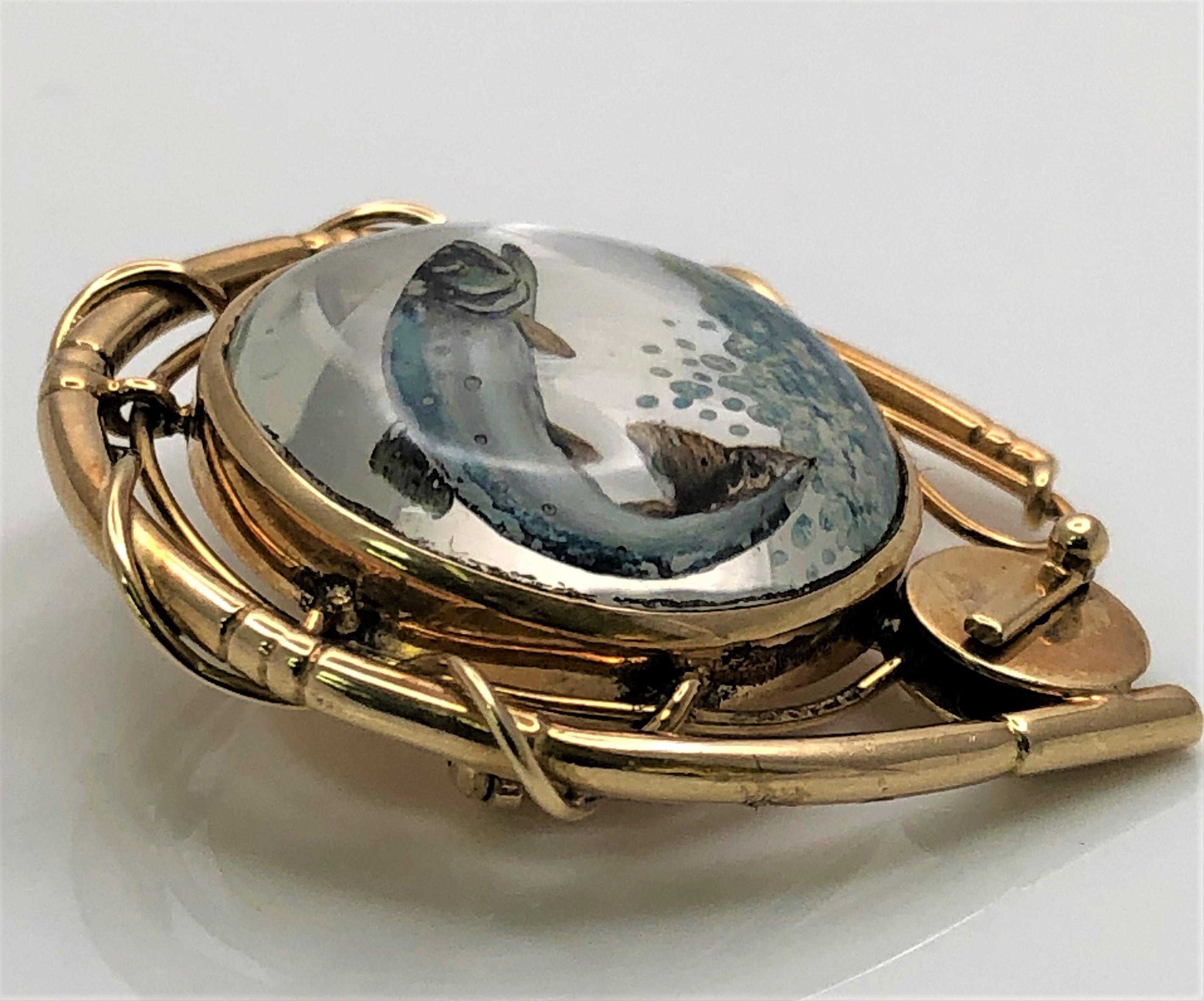 Il s'agit d'une broche unique en son genre.  Beaucoup de détails et parfait pour tout le monde !
Poisson volant peint au revers en 14KY, entouré d'une canne à pêche en forme de fer à cheval.
Fond en nacre.
Dimensions totales : environ 34 mm x 29 mm