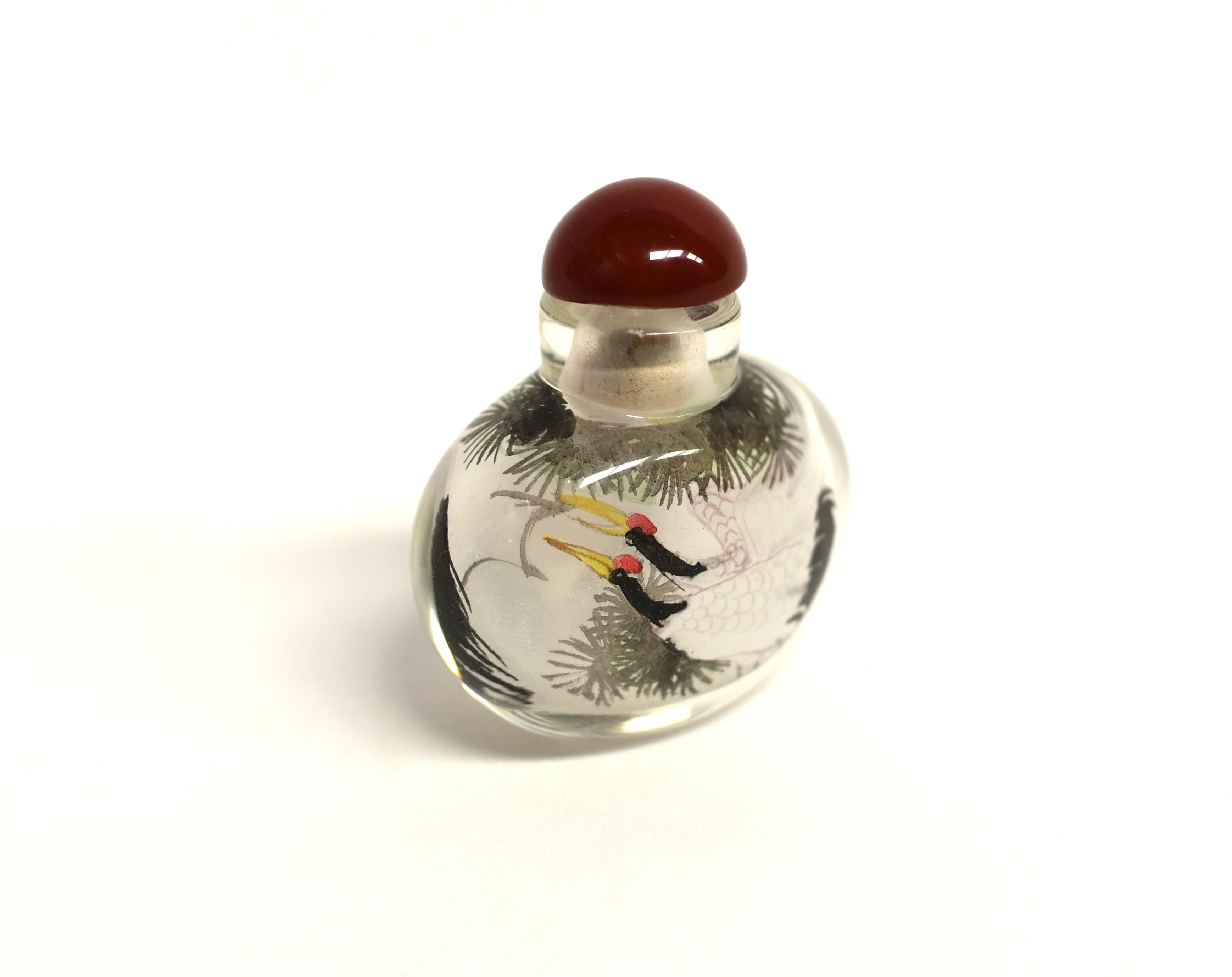 Our snuff bottles are topped with gemstone grade agate lids and 100% hand painted from within. The Chinese art of églomisé uses a very thin bamboo brush with a few strands of hair to apply watercolor on the inside walls of the blank glass bottle