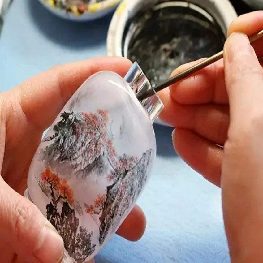 Our snuff bottles are topped with gemstone grade agate lids and 100% hand painted from within. The Chinese art of églomisé uses a very thin bamboo brush with a few strands of hair to apply watercolor on the inside walls of the blank glass bottle
