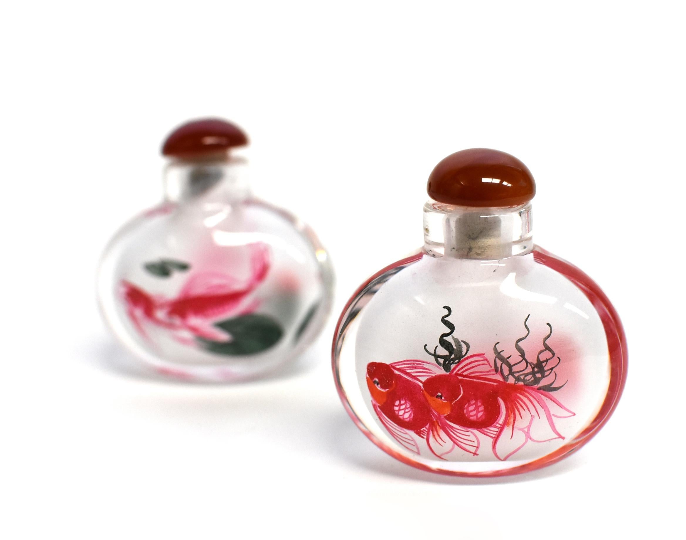 Our snuff bottles are topped with gemstone grade agate lids and 100% hand painted from within. The Chinese art of églomisé uses a very thin bamboo brush with a few strands of hair to apply watercolor on the inside walls of the blank glass bottle