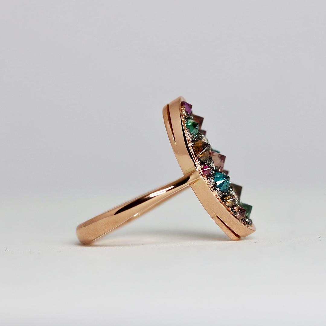 This ring in 18 K Rose gold, handmade in Belgium by jewellery designer Joke Quick, showcases a stunning mosaic of reverse-set blue, brown, purple diamonds and white diamonds. 
Expertly handcrafted without casting or printing, it promises a perfect,