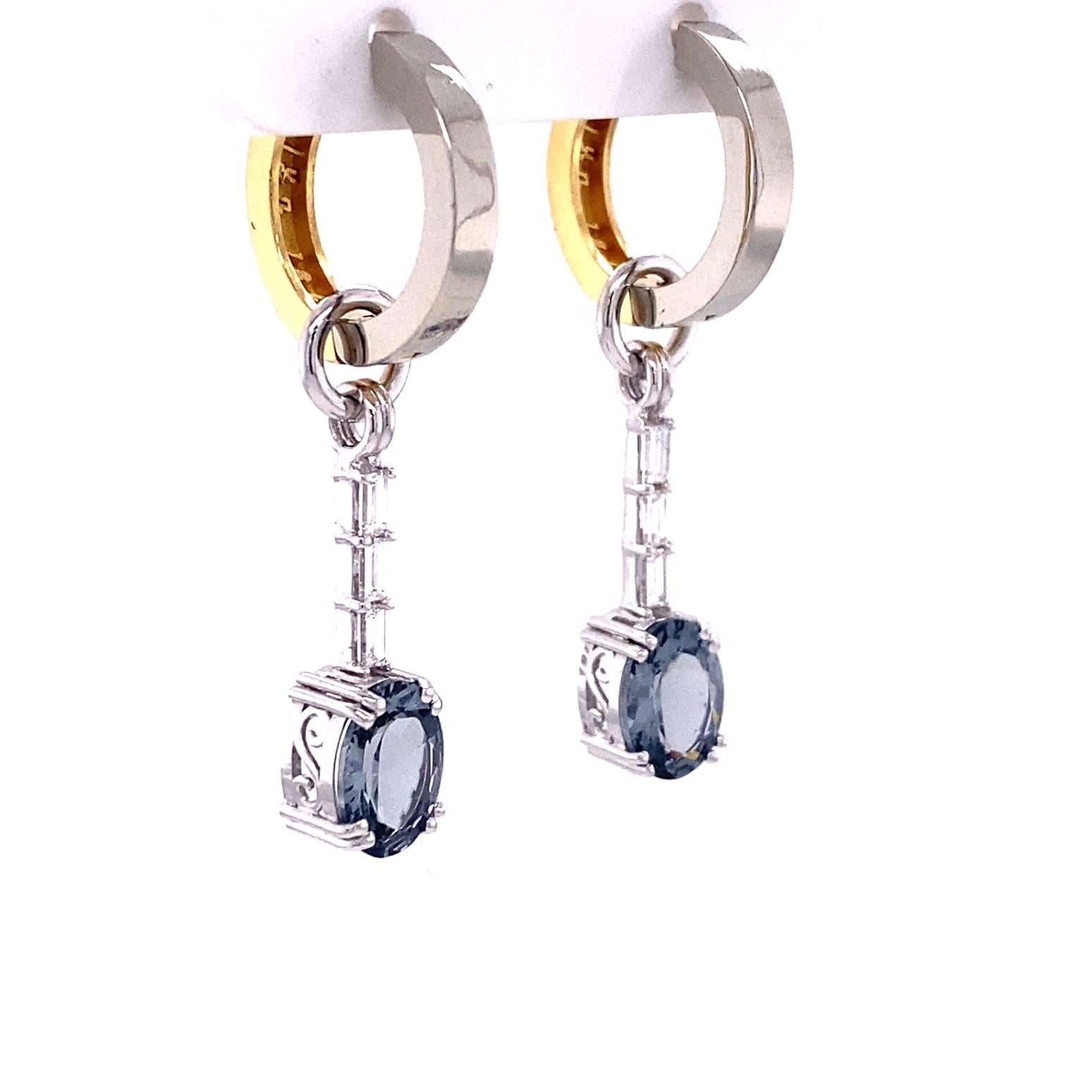 A pair of 18k white gold jackets set with 2.38 carats of oval gray spinel and 6 baguette diamonds, .29 total carat weight on a pair of reversible 18k white and yellow gold huggie hoops. Earrings designed and made by llyn strong.