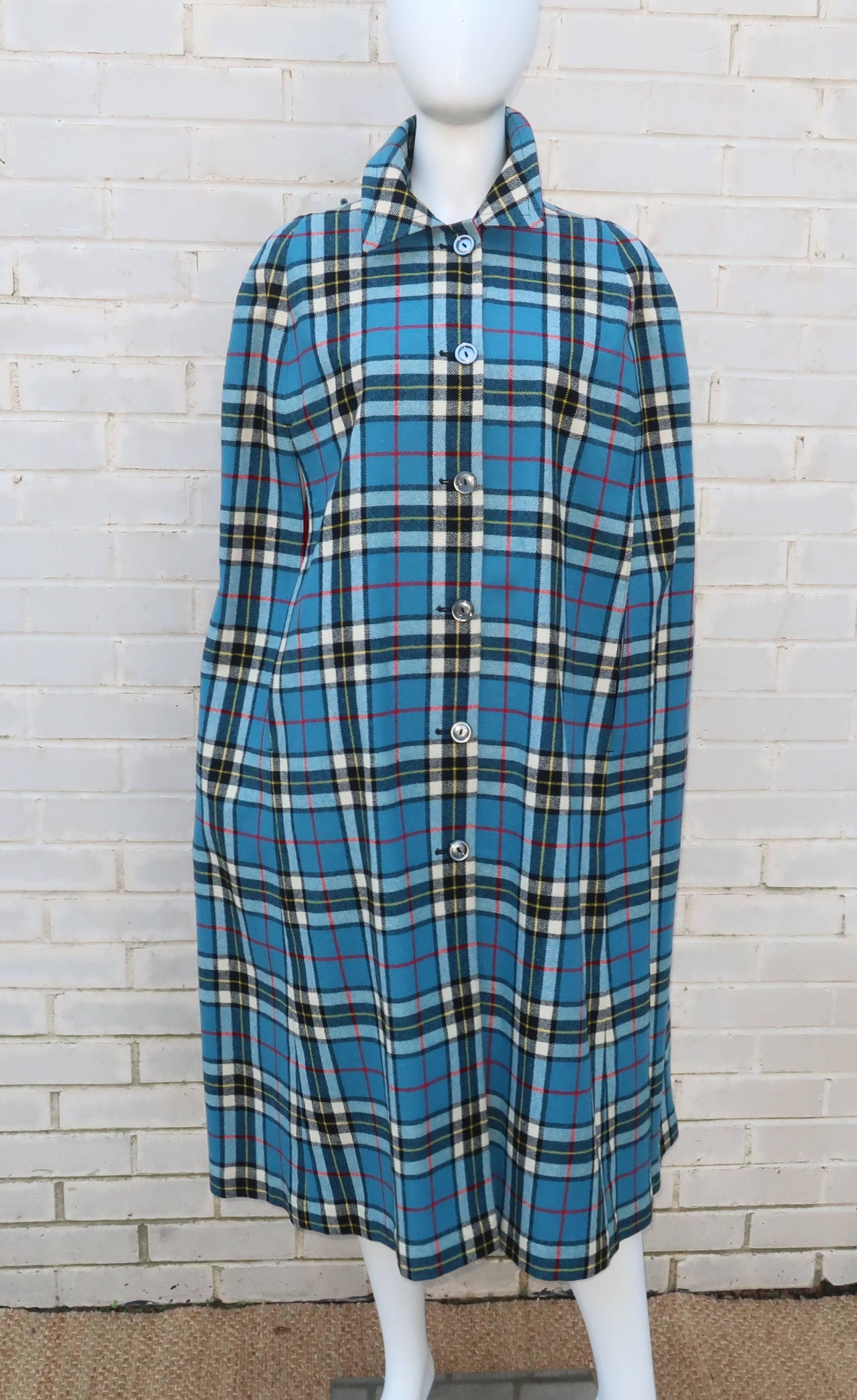 Two for the price of one!  This adorable 1960's cape is fully reversible for wear as a plaid wool topper or make a quick change to a red canvas wrap.  The plaid is a vibrant combination of cerulean blue mixed with white, red and black and really