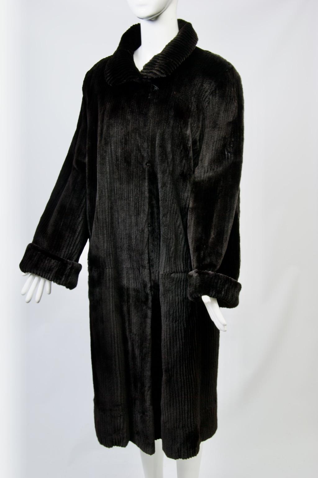 Un'aggiunta meravigliosa al tuo guardaroba invernale: questo cappotto vintage reversibile è attraente e versatile. Il lato della pelliccia è composto da pelo nero tosato, molto lucido e morbido al tatto, a strisce verticali strette. Se lo giri al