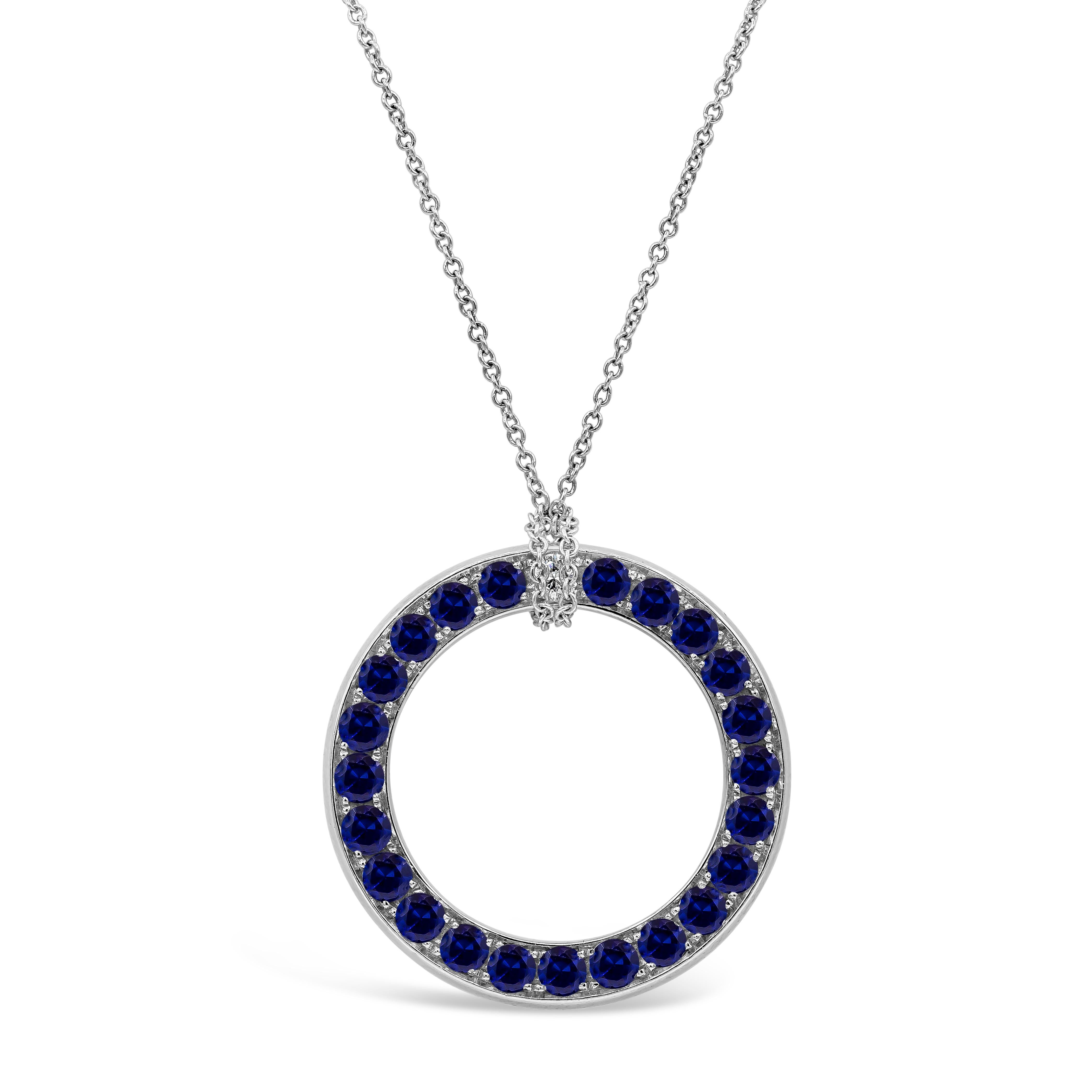 A unique circle pendant necklace showcasing round brilliant diamonds weighing 1.60 carats total on one side, and reverses to round blue sapphires weighing 1.80 carats total on the other side. Finely made in 18K white gold and attached to an 18