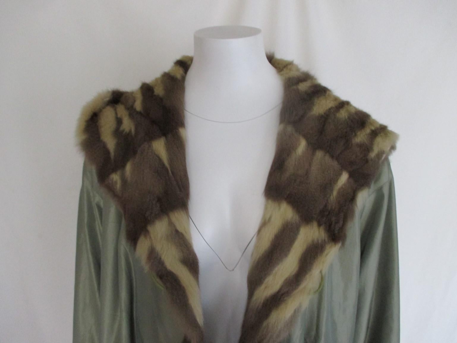 This vintage coat with hood can be worn at both sides, it has 2 buttons and 2 pockets at the fur side and at the other side 2 pockets and 2 buttons.
Sleeves can roll up and down
The colour is shiny green fabric
Very light to wear
In good pre-owned