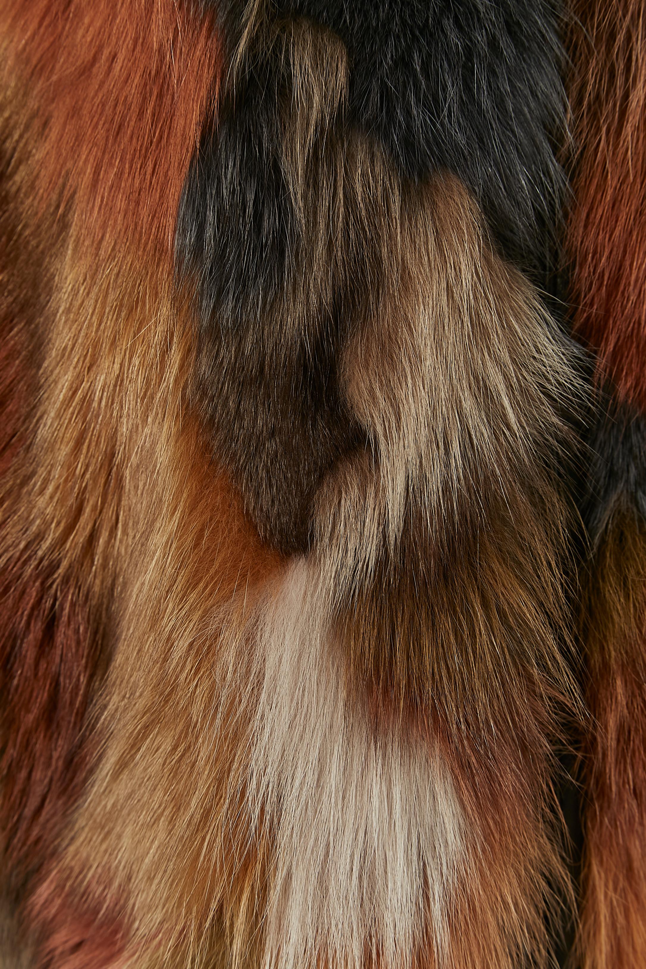 Gilet réversible en fourrure multicolore avec intérieur en cuir. Pochette sur les deux côtés, à l'intérieur et à l'extérieur. Fermeture à glissière sur le milieu du devant. Col 
Taille sur l'étiquette XL 