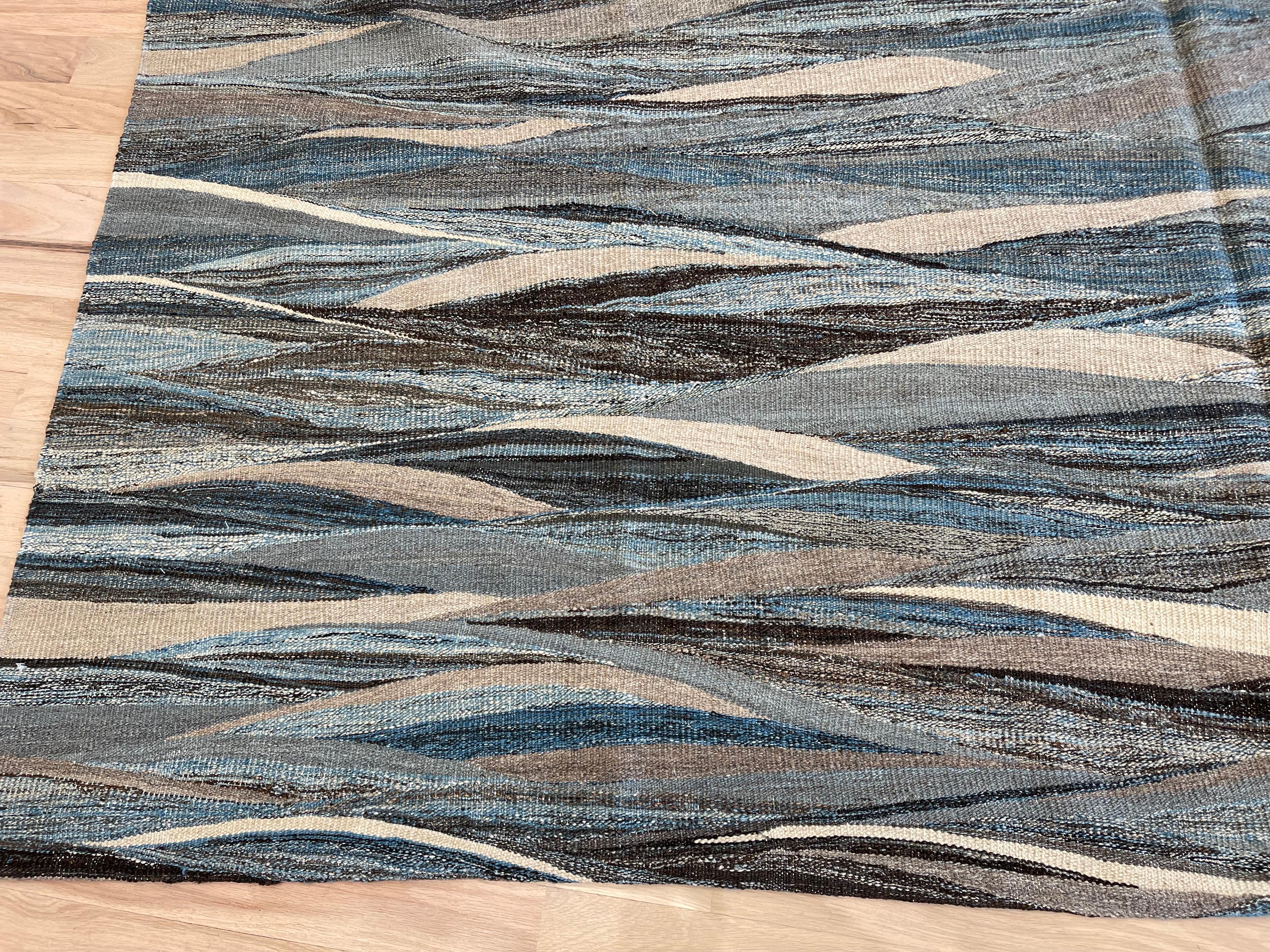 Verwandeln Sie Ihren Raum mit unserem schönen türkischen Teppich, der ein elegantes Wellenmuster in Blau-, Grau-, Beige- und Weißtönen aufweist. Er ist aus hochwertigen MATERIALEN gefertigt und lässt sich für vielseitige Stylingoptionen wenden.