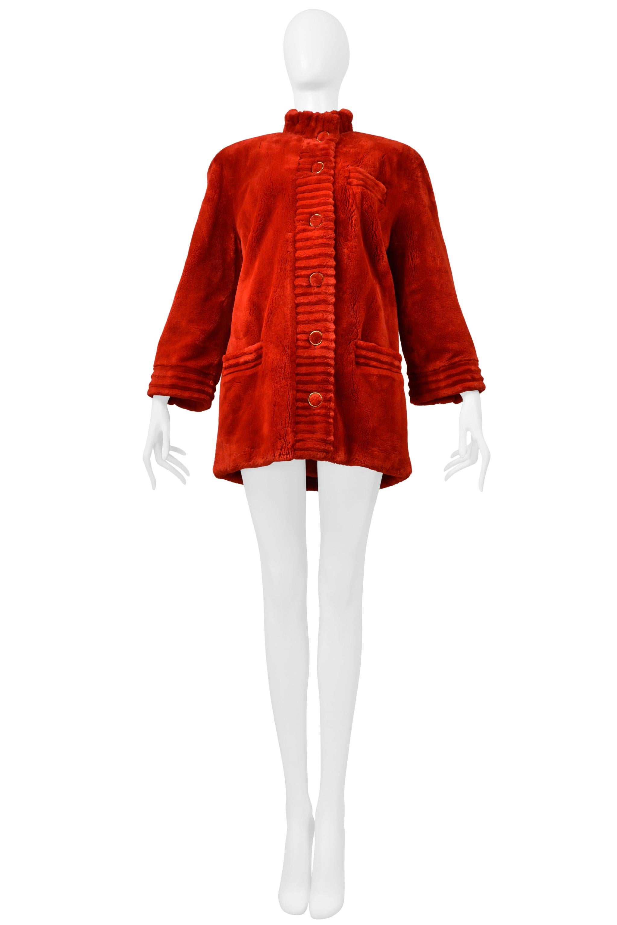 Resurrection Vintage se complace en ofrecer un impresionante abrigo Revillion de piel de castor esquilada en rojo, con cuello alto, ribete cortado en cresta, cierre frontal con botones, bolsillos laterales, botones dorados, forro rojo y largo hasta