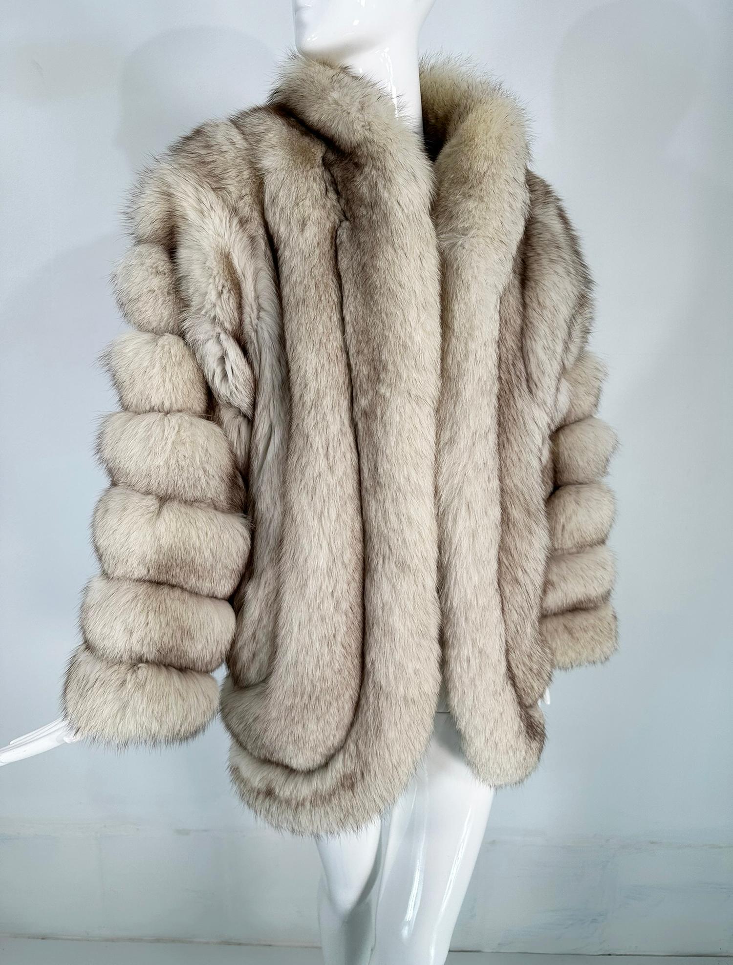 Revillon silver fox 3/4 length coat from the 1980s. Natural silver fox raglan sleeve coat  is done in horizontal bands on each sleeve, with narrow, not seen, bands of silvery white suede. The front facings incorporate the collar and front edges