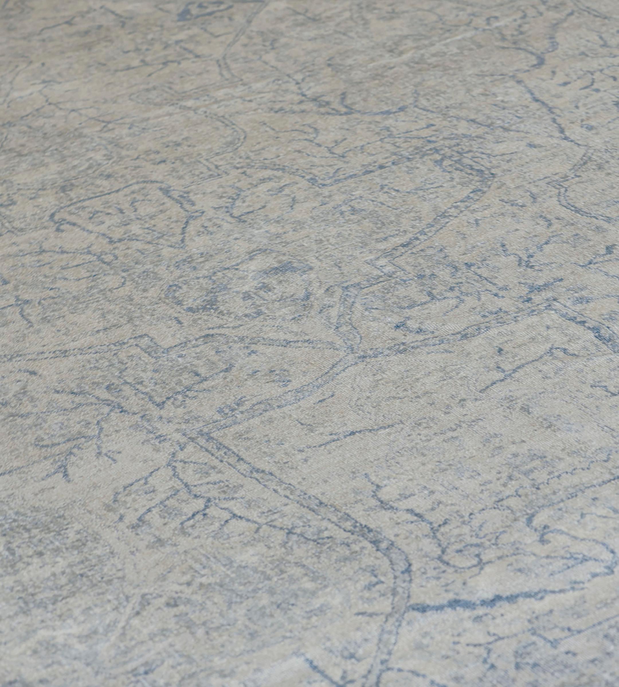 Questo tappeto Kirman revival ha un campo avorio sfumato con un disegno generale di palmette e fiori blu mare sfumati, con un bordo blu mare di fitte teste di fiori tra doppie strisce di fiori avorio sfumati.