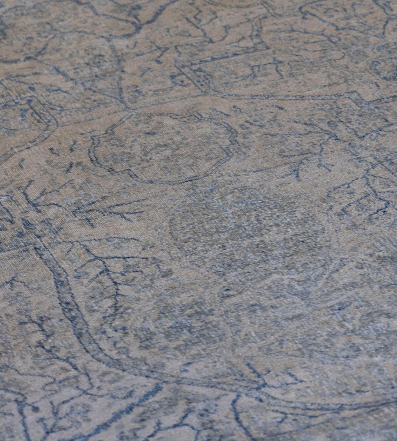Ce tapis Kirman de renaissance présente un champ ivoire nuancé avec un motif général de palmettes délicates et de vignes florales bleu marine nuancé, dans une bordure bleu marine de vignes à têtes de fleurs denses entre deux bandes de vignes
