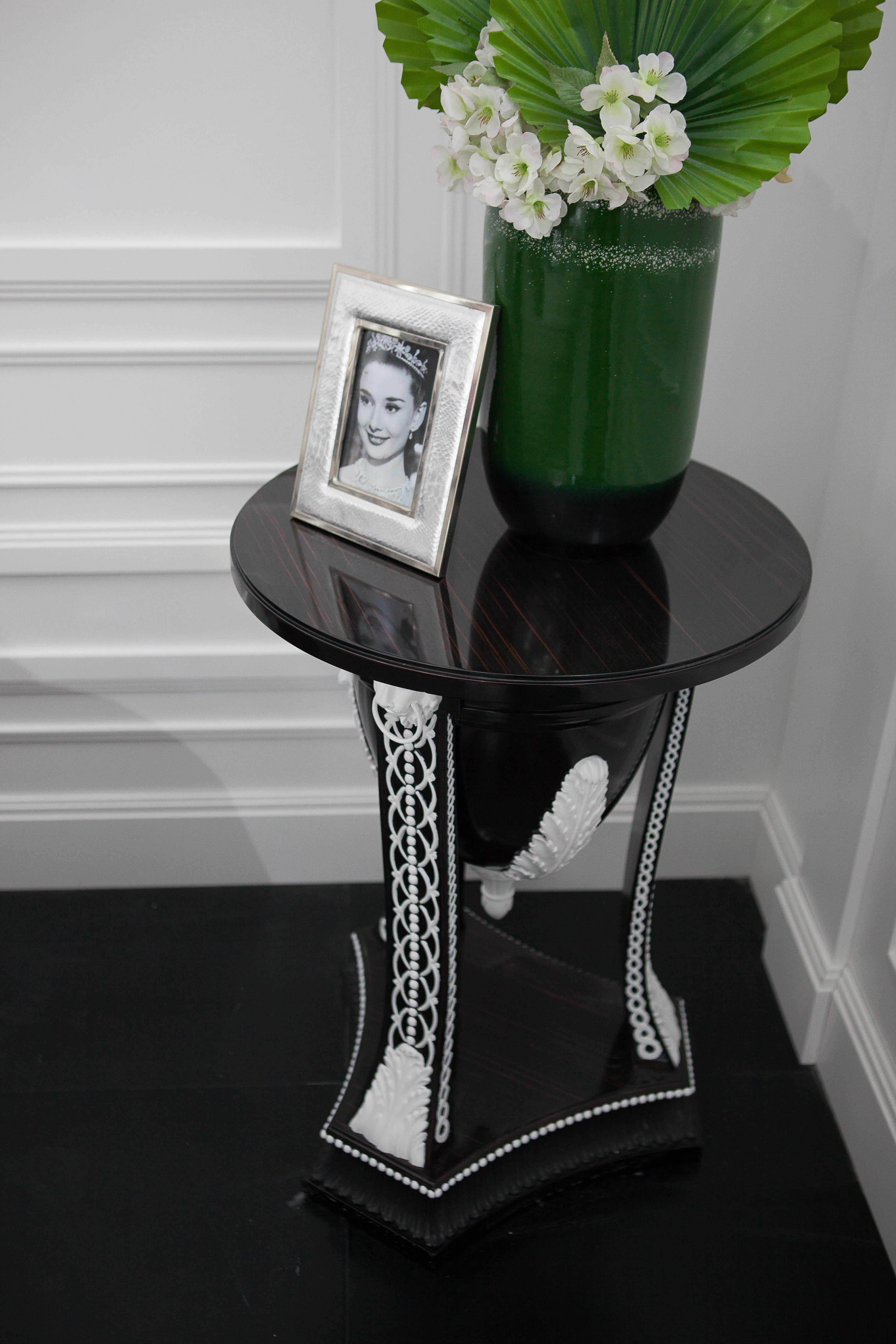 Table d'appoint en bois d'ébène avec éléments sculptés en blanc, style néoclassique

Ajoutez une touche d'élégance et de sophistication à votre espace de vie avec notre table d'appoint artisanale en édition limitée. Cette pièce étonnante présente