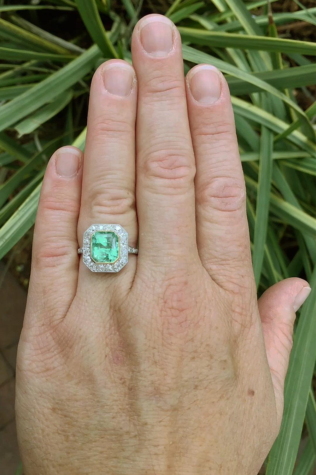 This enticing 3 carat Colombian emerald and diamond engagement ring, skillfully rendered in the Art Deco style features a large and lush gemstone. The octagon halo shimmering with 16 old European diamonds supported by a pierced filigree platinum and