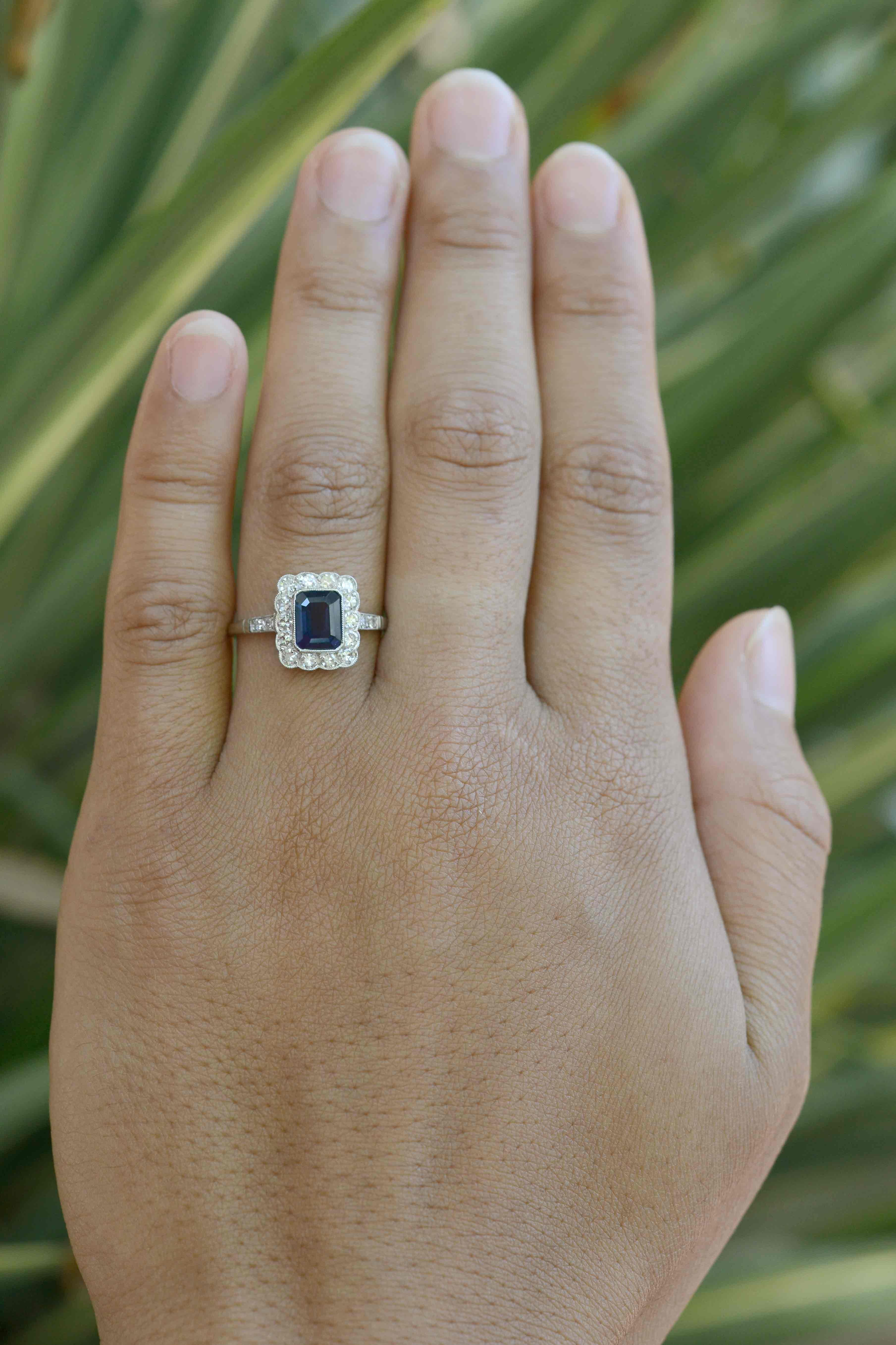 The Jackson 2 carat Art Deco Style sapphire engagement ring. Floating in a pool of diamonds is a most richly saturated deep blue, emerald cut sapphire in a dainty, scalloped millegrained bezel. We love the halo exhibiting an enchanting, undulating