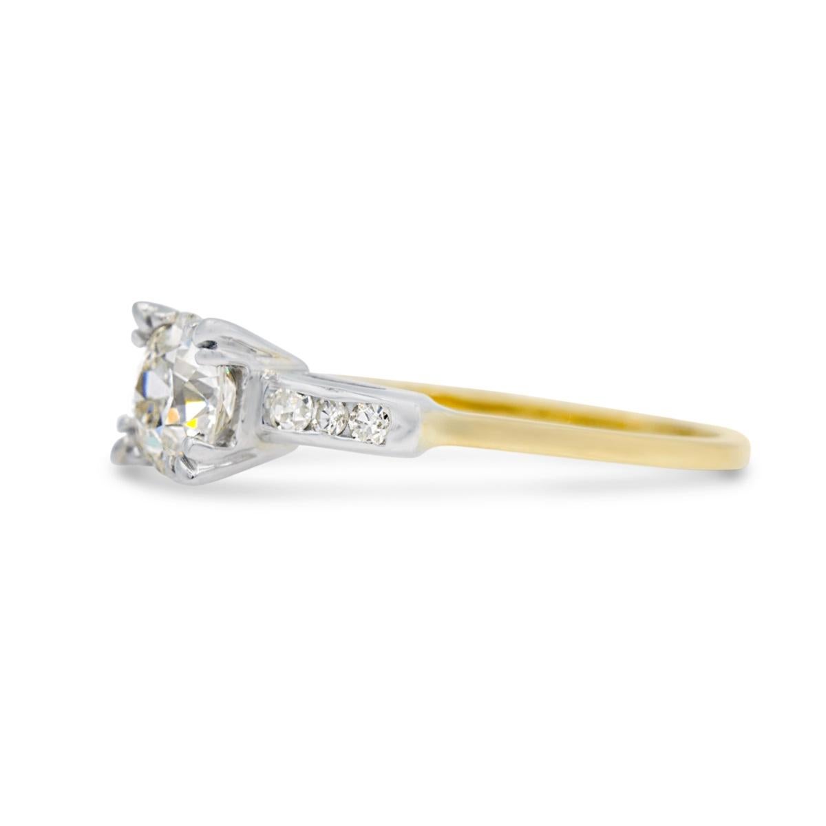 This classic Edwardian era two-tone engagement ring is centered by a beautiful 1.04 old European diamond. The ring is set with fishtail prongs and shouldered by 6 channel set single cut diamonds. We love the two-tone look, as a way to spice up this