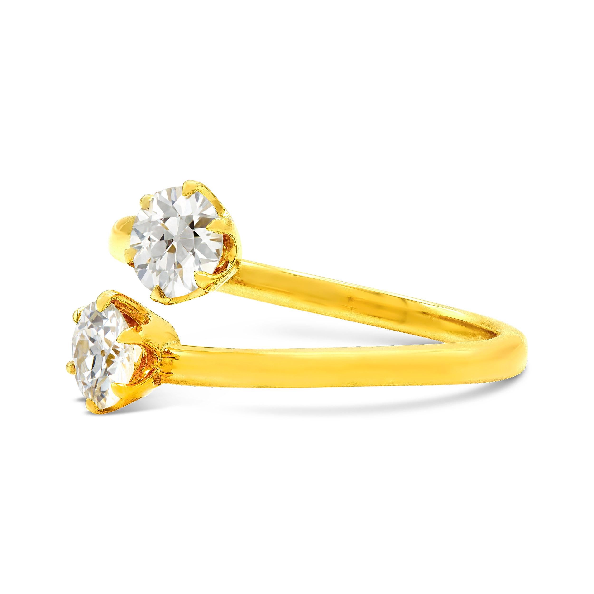 When it comes to diamonds, two are always better than one. We created this revived style with two matching antique old European cut diamonds, set on a bypass style band, weighing a full carat together. This yellow gold ring is a sleek and modern