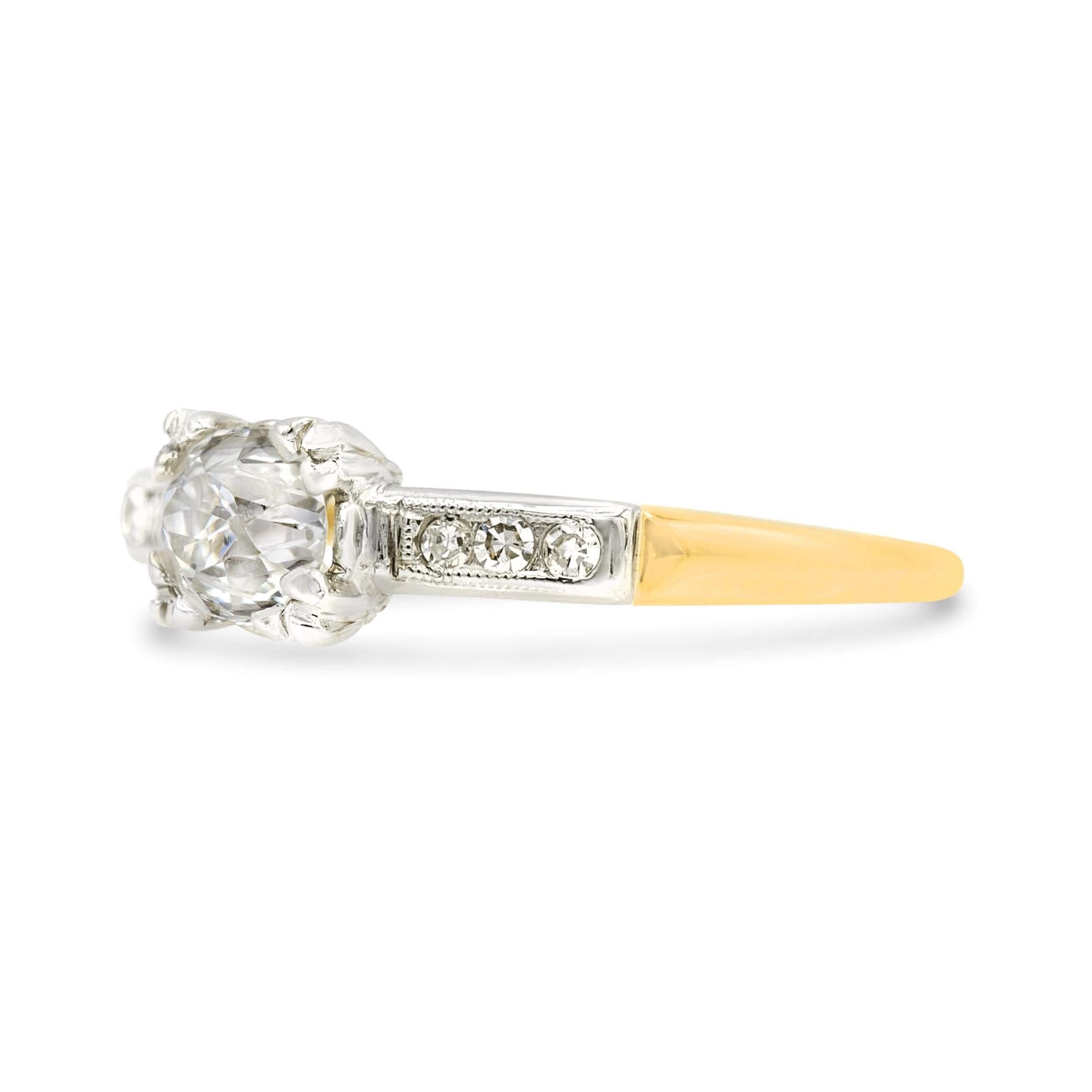 At the center of this sweet and charming ring sits a lively old European diamond. It has classic antique proportions with a small table and chunky facet patterns. The nearly colorless diamond shines bright in a fishtail prong basket and is accented