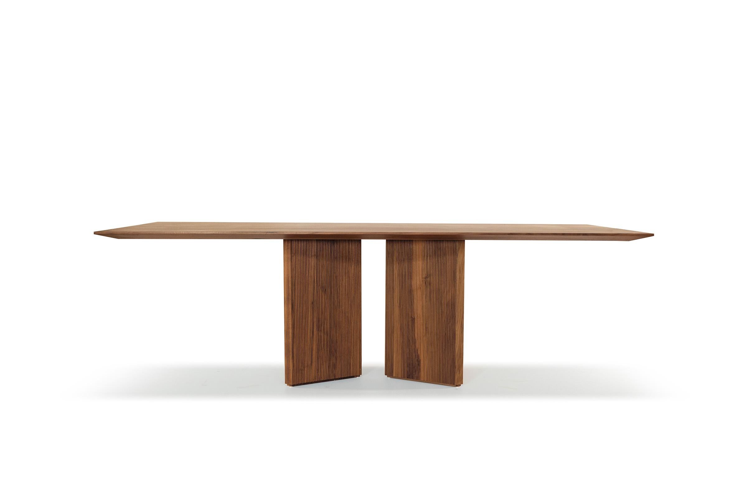 Table with top made of solid wood glued lists with thin edges. The base consists of prism-shaped legs, each characterized by three solid wood vertices, and surfaces that can be smooth or with Fresart processing, which creates a modern and dynamic