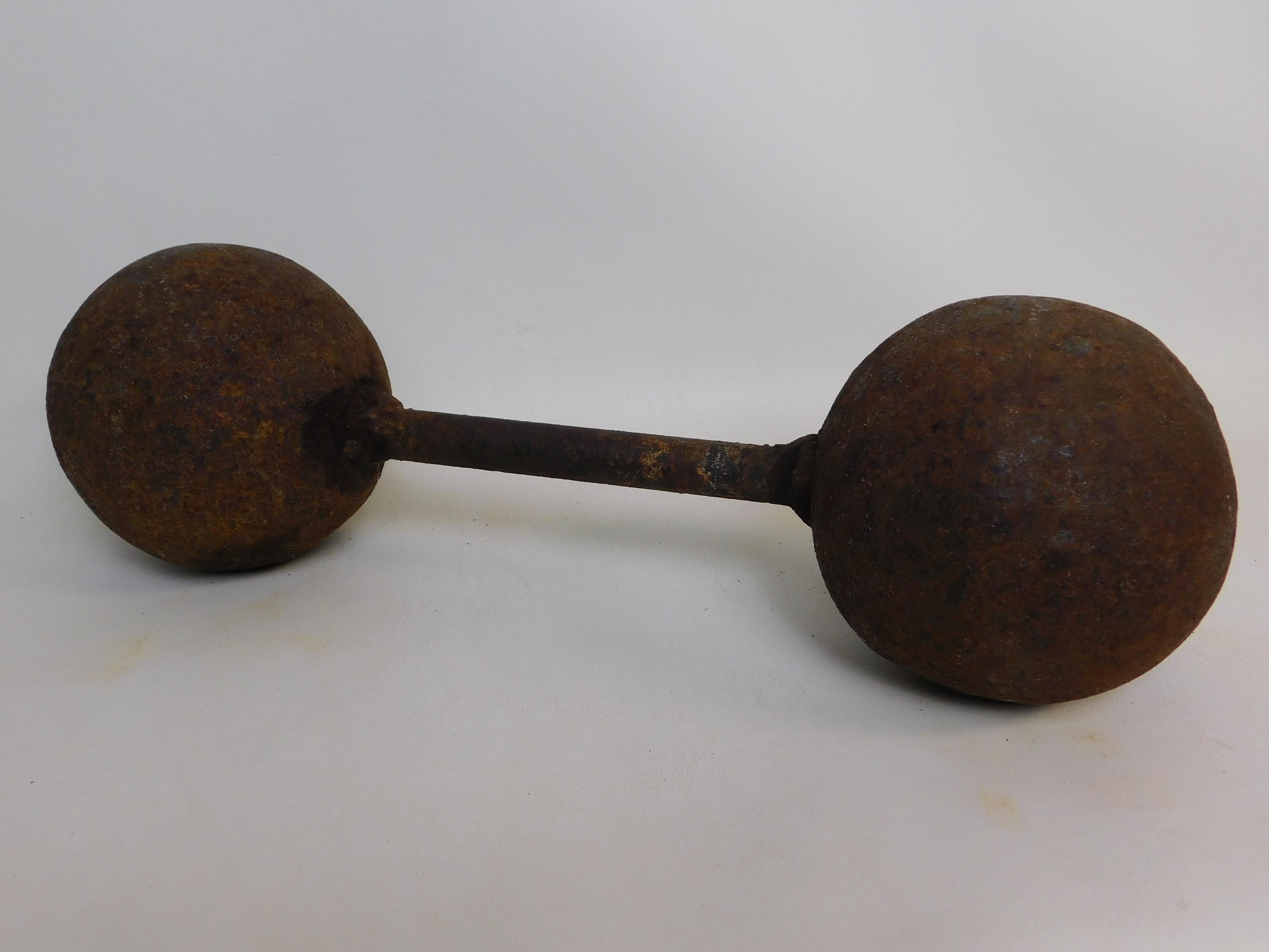 This is a 18th century circa 1776 heavy iron metal bar shot double cannon ball connected by a metal bar. It weighs a heavy 50 pounds (22.6796 kilos), measures 16 inches long (40.64 cm), each ball 5 inches (12.7 cm) in diameter. 

Bar Shot/Chain
