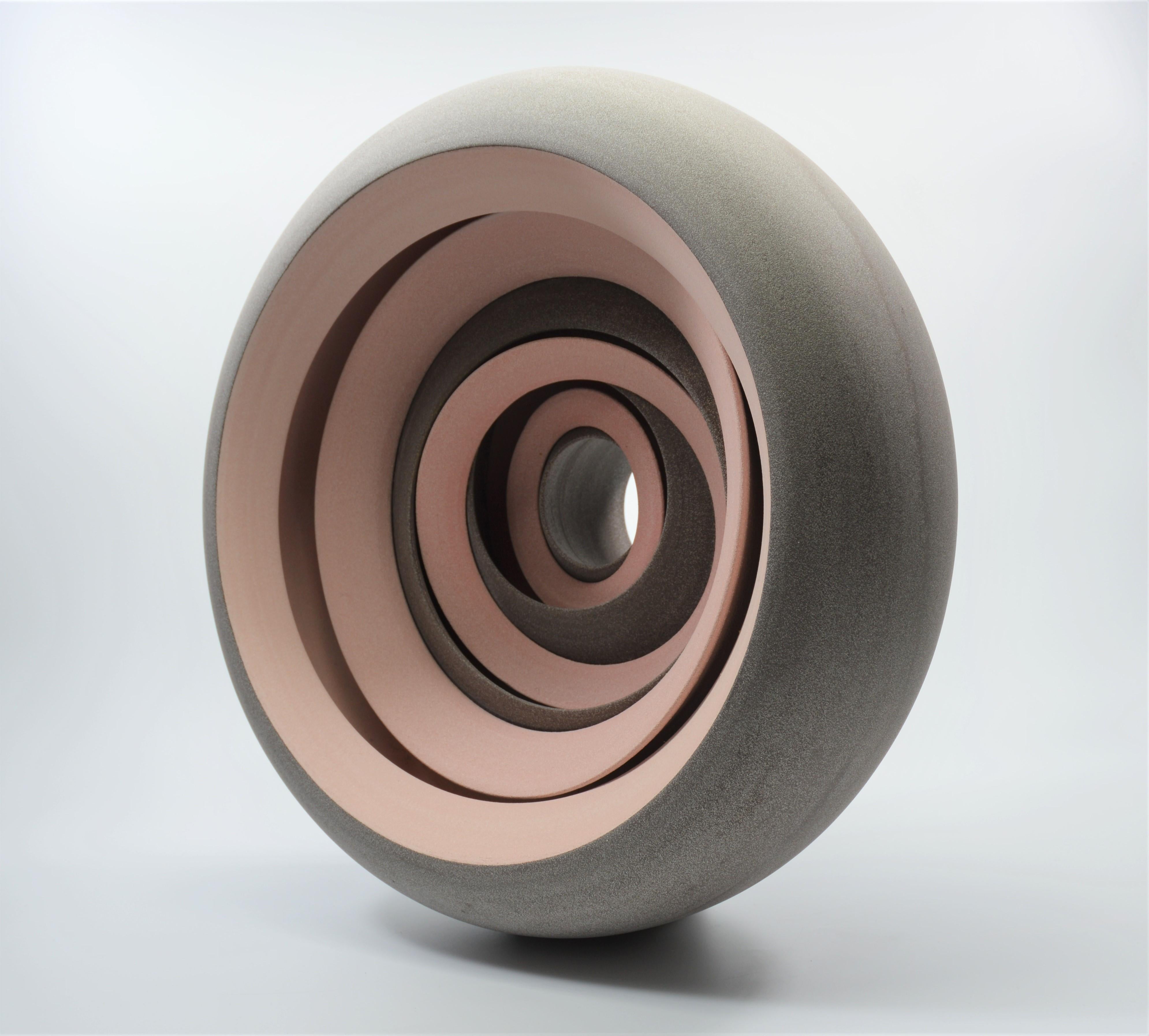 This mesmerising, subtly coloured pink and light grey, circular ceramic sculpture by Matthew Chambers is a true testament to this artist's highly accomplished technical skill and complete understanding of form. Matthew's ceramic sculptures push the