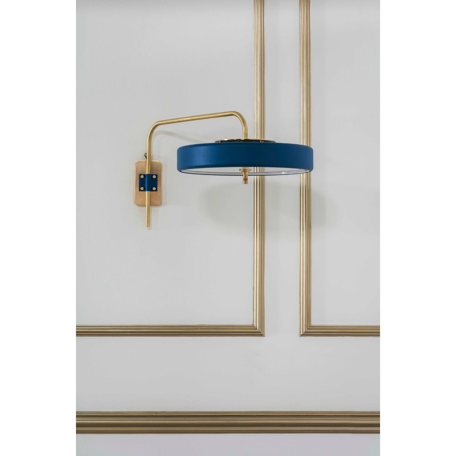 Revolve wall light - brushed brass - blue by Bert Frank
Dimensions: 31 x 63 x 35 cm
Materials: Brass, steel

Available in polished brass

Flush-fitting opal glass shade with central dome of polished marble – white Carrara or green Guatemala – held