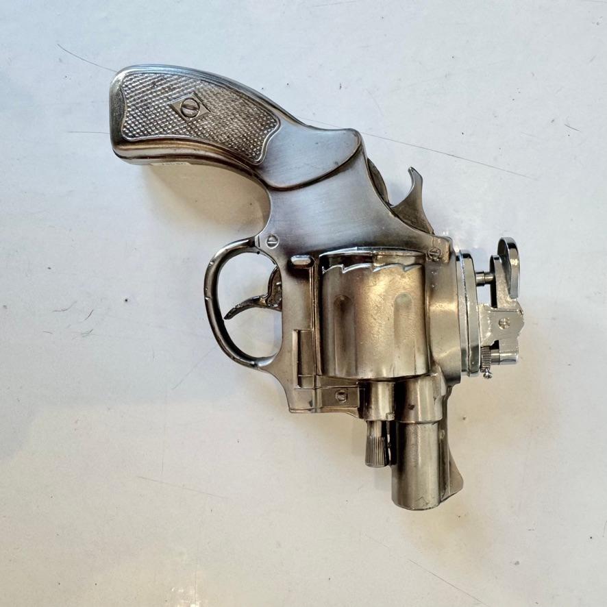 Dieses hübsche Feuerzeug ist in der Form eines Revolvers gegossen. Perfekt für jeden Sammler von Rauchutensilien oder Schusswaffenliebhaber. Die akribische Liebe zum Detail macht den Film zu einer überzeugenden Hommage an sein Ausgangsmaterial. Der
