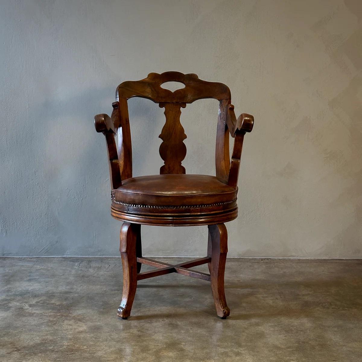 This swivel armchair by Luigi Filippo is crafted from walnut, featuring the original leather upholstery. The chair combines functionality with aesthetic appeal, highlighted by its elegant curves and detailed wood carvings.

Italy, Circa
