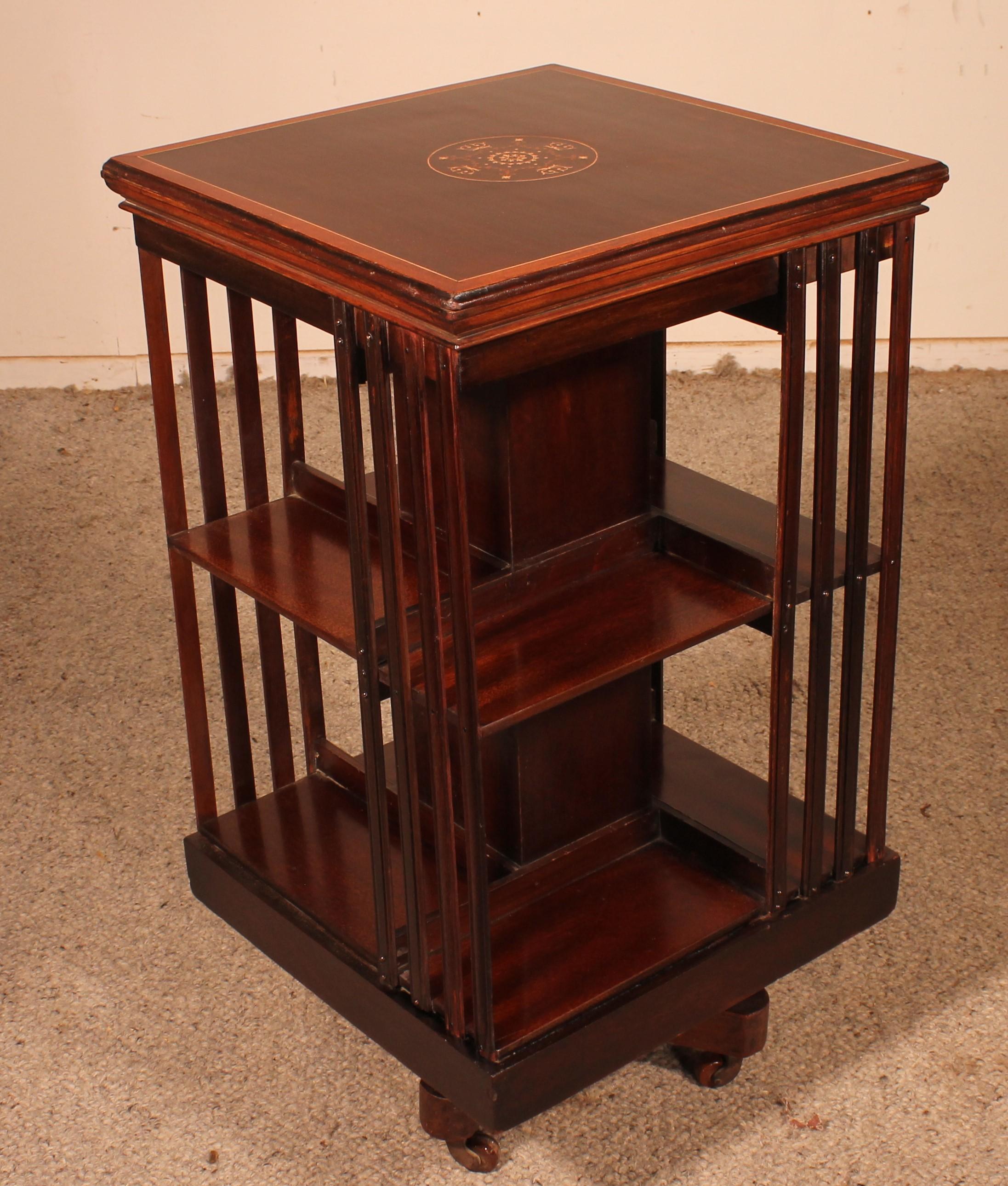 Elegant revolving bookcase in mahogany and inlays from the end of the 19th century from England.
Very beautiful mahogany bookcase which has a very beautiful table top with a medallion in marquetry as well as lemon tree inlays.

Very beautiful