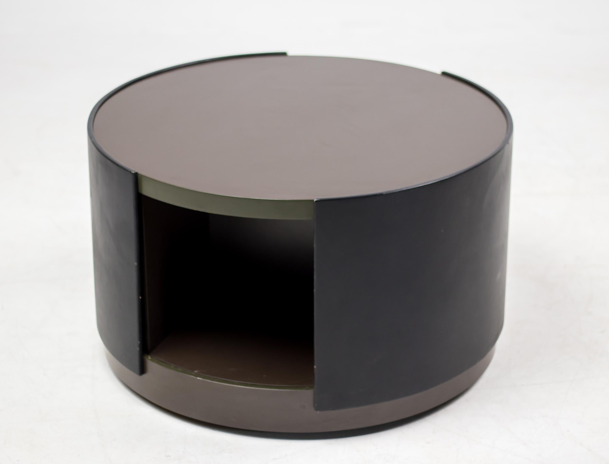 This rare round cabinet on hidden wheels designed by Osvaldo Borsani for Tecno is made out of lacquered plywood, laminate, leather and steel. The dark grey lacquered plywood interior revolves inside the black leather clad exterior. Manufacturer's