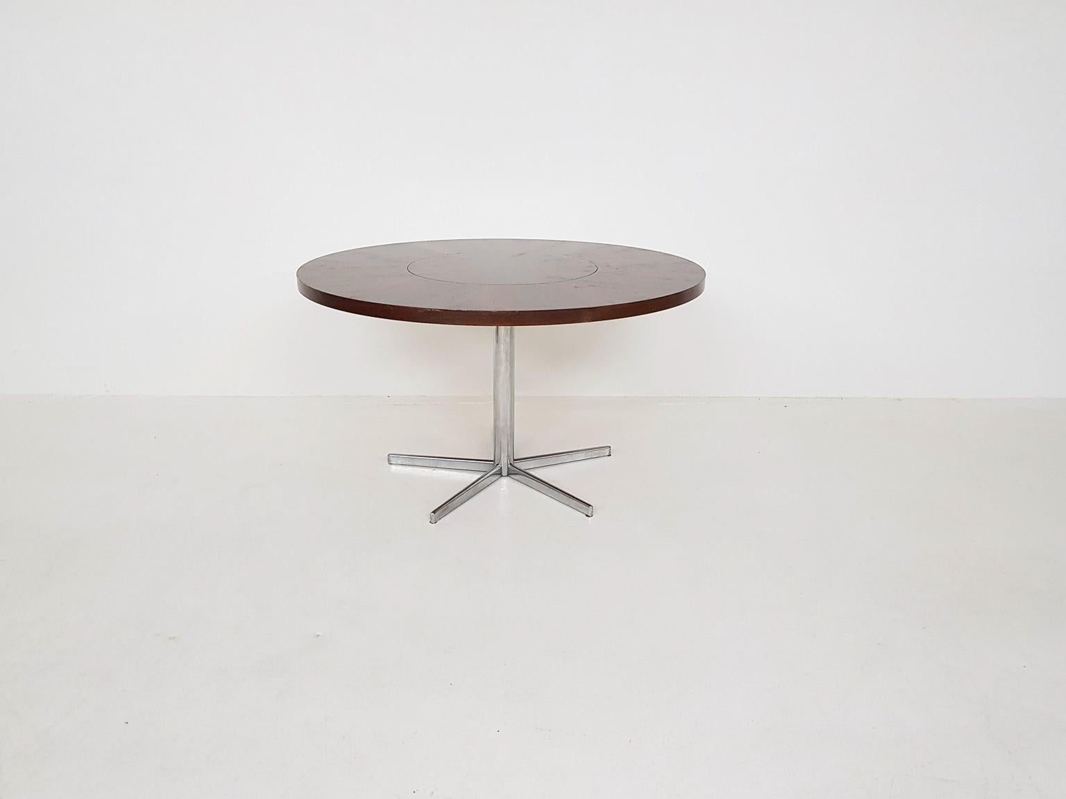A unique pedestal dining table with a rotating centre, made of rosewood veneer on a metal, chromed base. This table is made by the German manufacturer Emü in the 1960s.

The top of the table consists of two parts. The outer rosewood circle is