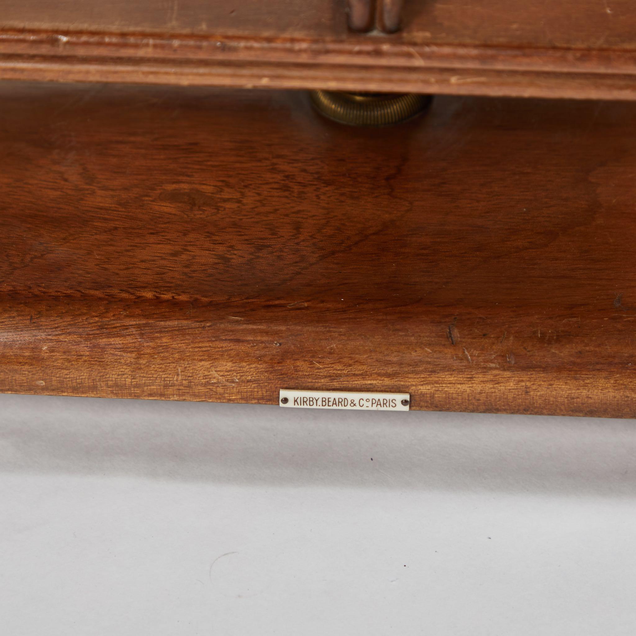 A revolving side table in mahogany with brass trim, originating in France, circa 1940.