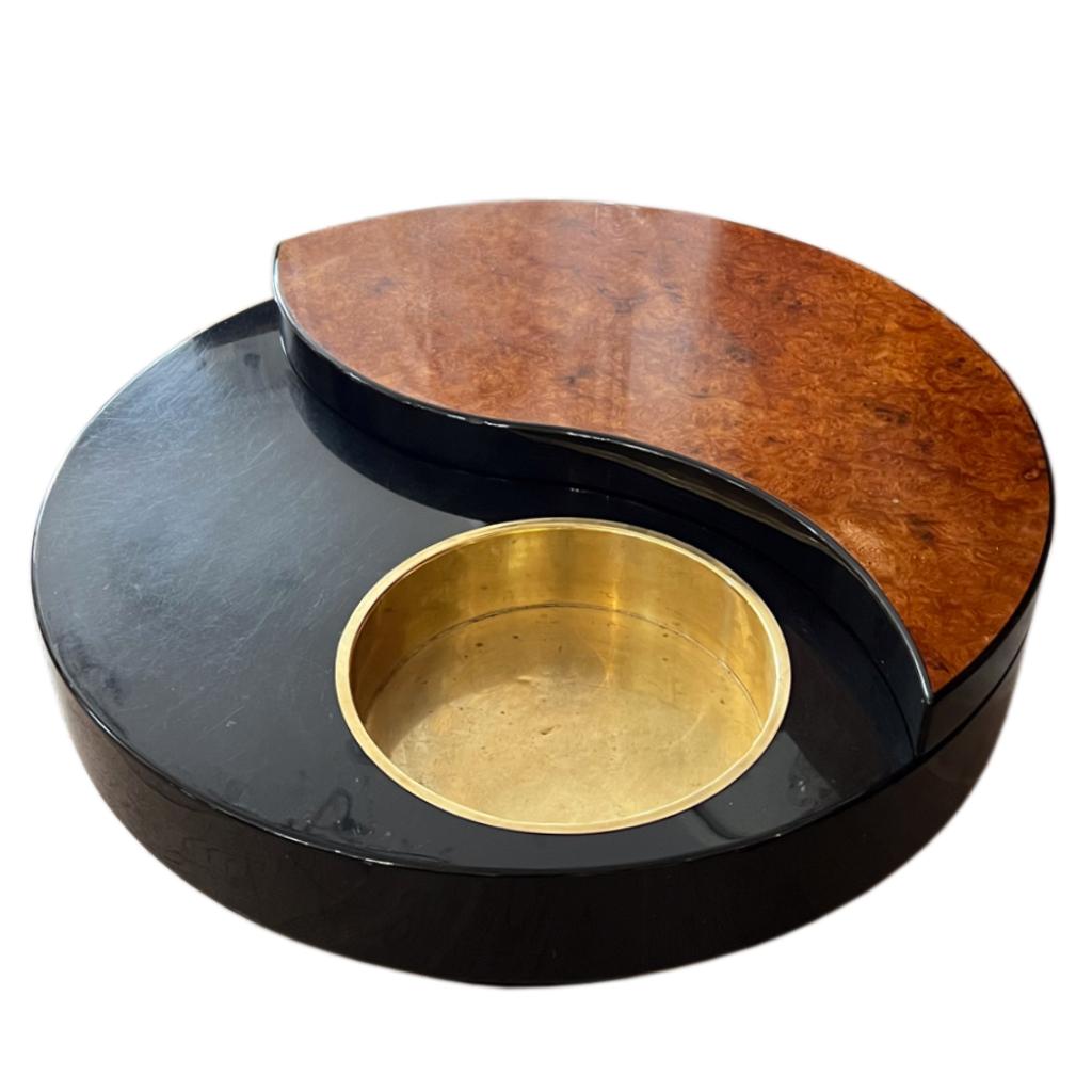 Une magnifique table basse tournante Yin Yang, par Willy Rizzo. Italie vers 1970. 
Pièce de créateur originale des années 1970. 
Avec un superbe plateau encastré en laiton pour les bouteilles, avec un socle et des côtés en stratifié brun et noir.