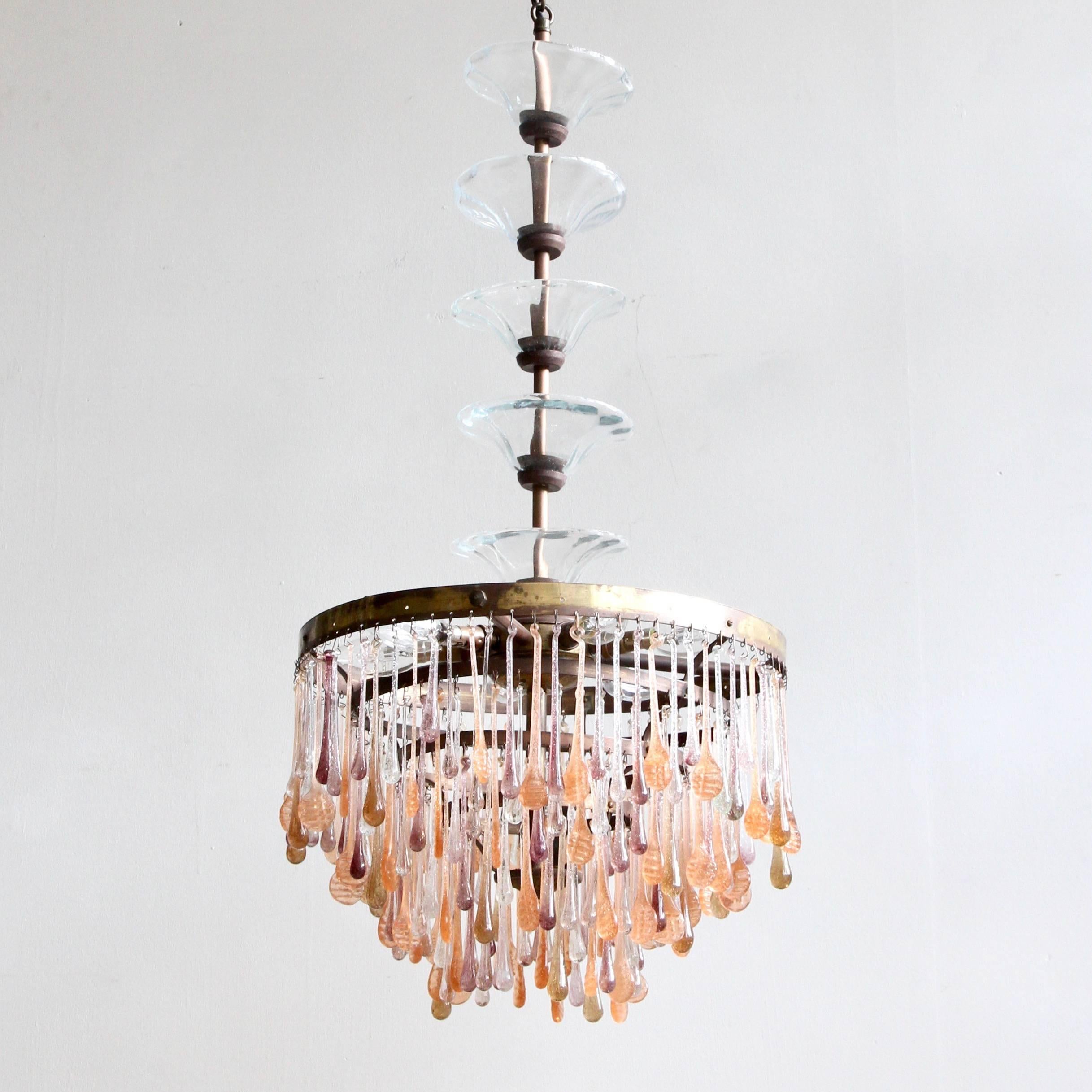 This coloured teardrop waterfall chandelier is dressed in shades of amethyst, peach and clear glass teardrops. We bought this old light in France and it was missing the whole top section and all its drops so we made a new top with a tall brass stem