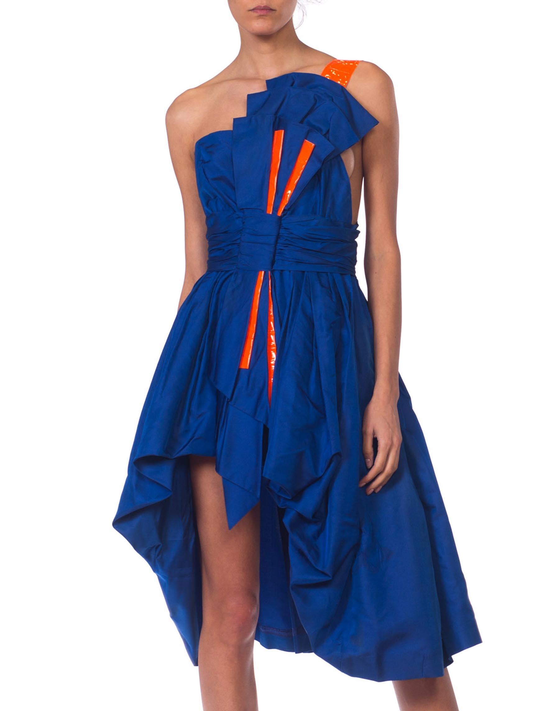 MORPHEW COLLECTION Sapphire Blue  Silk Taffeta Reworked 1950S High-Low Cocktail Dress With Large Bow & Neon Orange Accents
MORPHEW COLLECTION is made entirely by hand in our NYC Ateliér of rare antique materials sourced from around the globe. Our