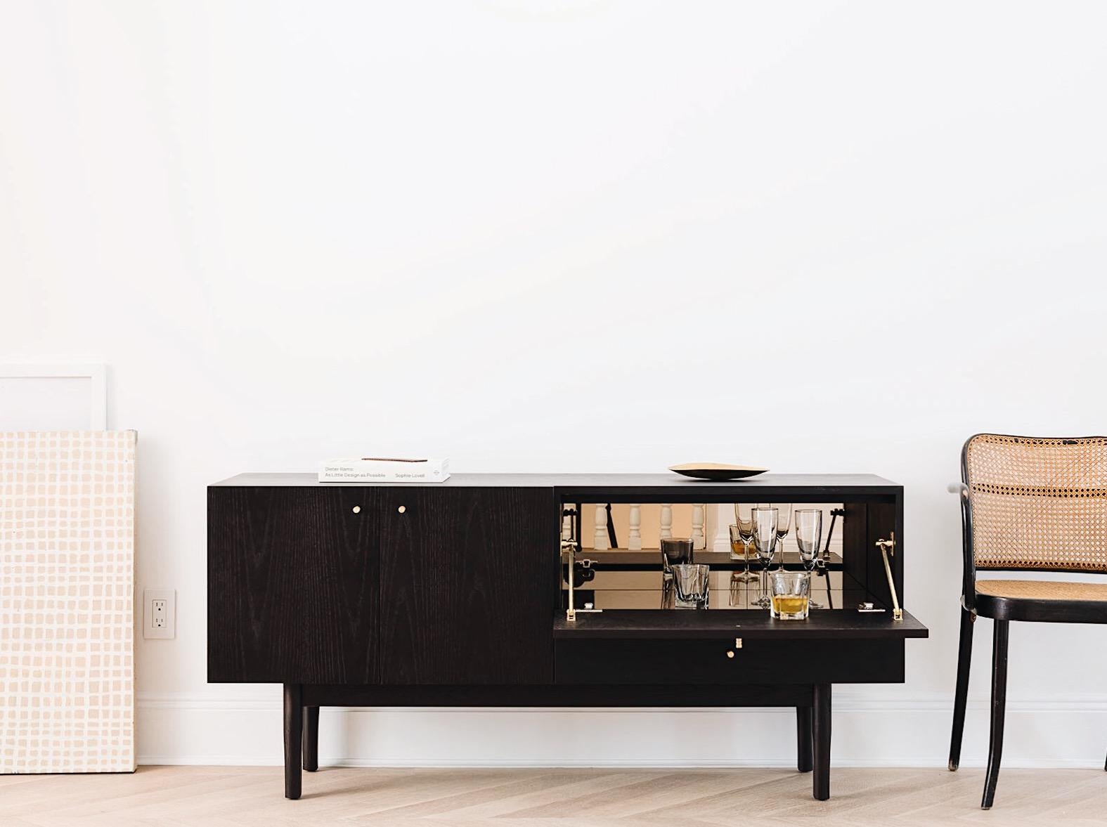 Inspired by the textural complexity of wood grain, the Rex sideboard is a celebration of organic character and clean, balanced line. Featuring machined brass pulls throughout, the left compartment includes two doors opening to an adjustable shelf