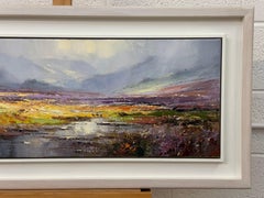 A serene moorland scene with rich hues, misty hills, and a reflective waterway