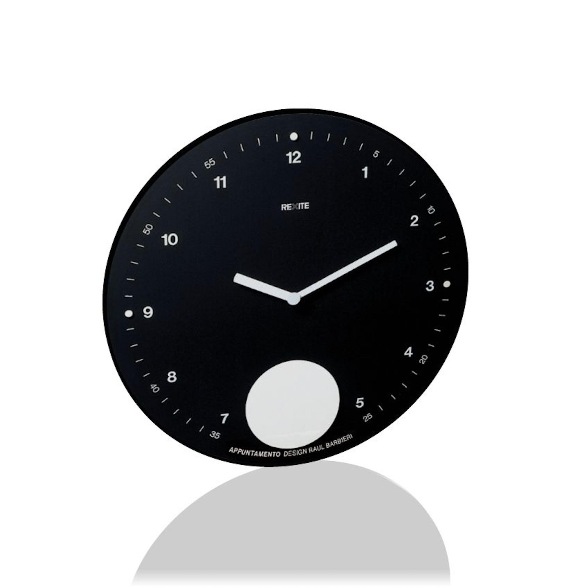 The Appuntamento Black wall clock by Rexite is based on a concept that is both simple and striking: the traditional circular wall clock is combined with a pendulum mechanism that sets a lower disc into a gentle oscillation. This subtle movement