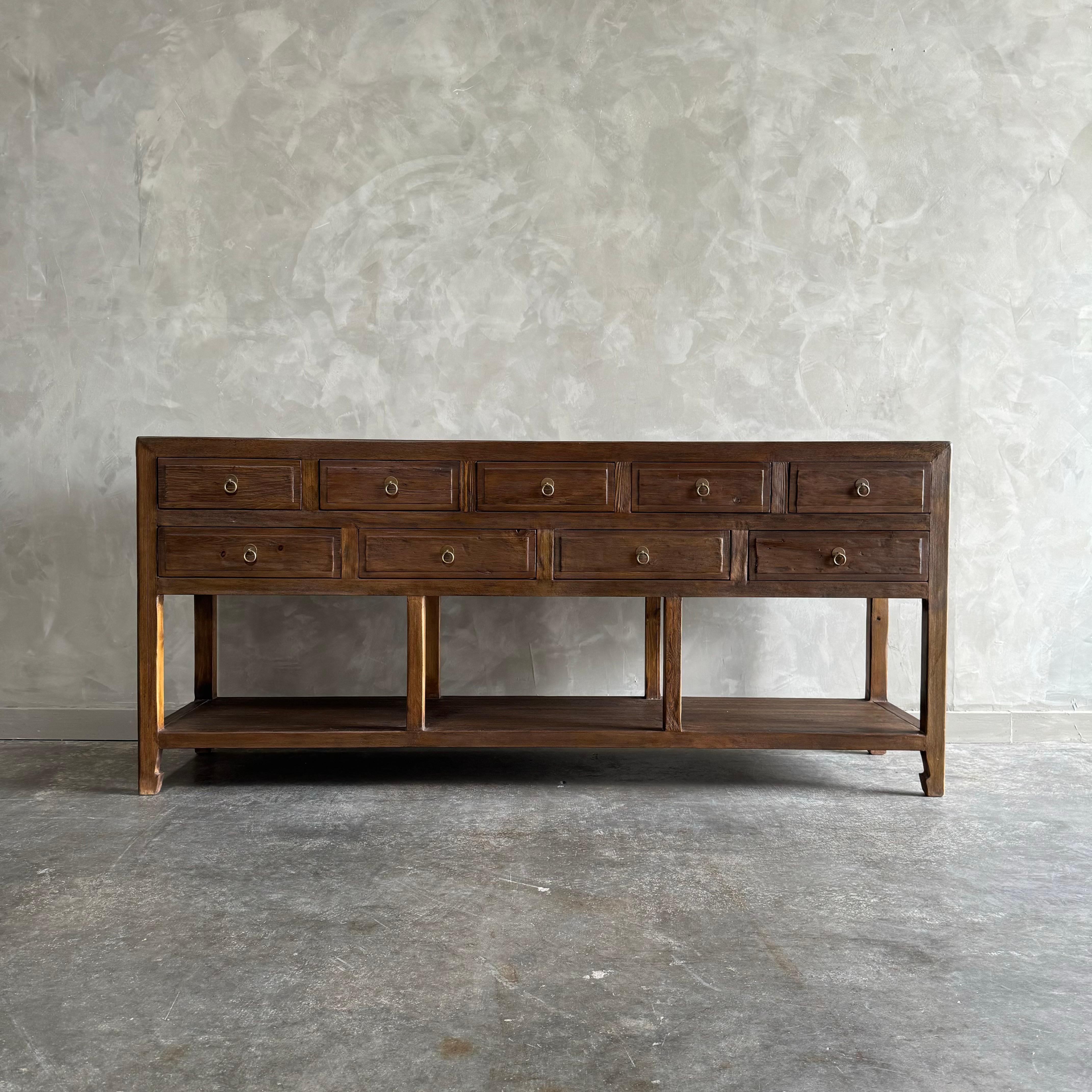 Our custom made console is a perfect blend of style and functionality. Crafted with reclaimed wood in a walnut finish, this console will add a timeless look to any space. With its abundance of drawers, it serves as an excellent entry piece or