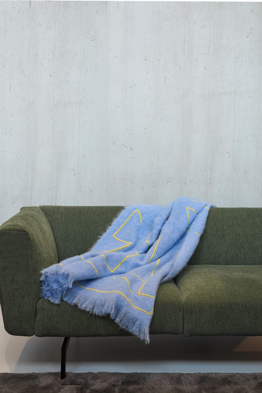 Reyburn, a graphic blanket made of the finest New Zealand mohair. This throw is embellished with contrasting embroidery done by hand. Nothing as personal as your own interior, the colors of the fabric and embroidery can be customized on request.