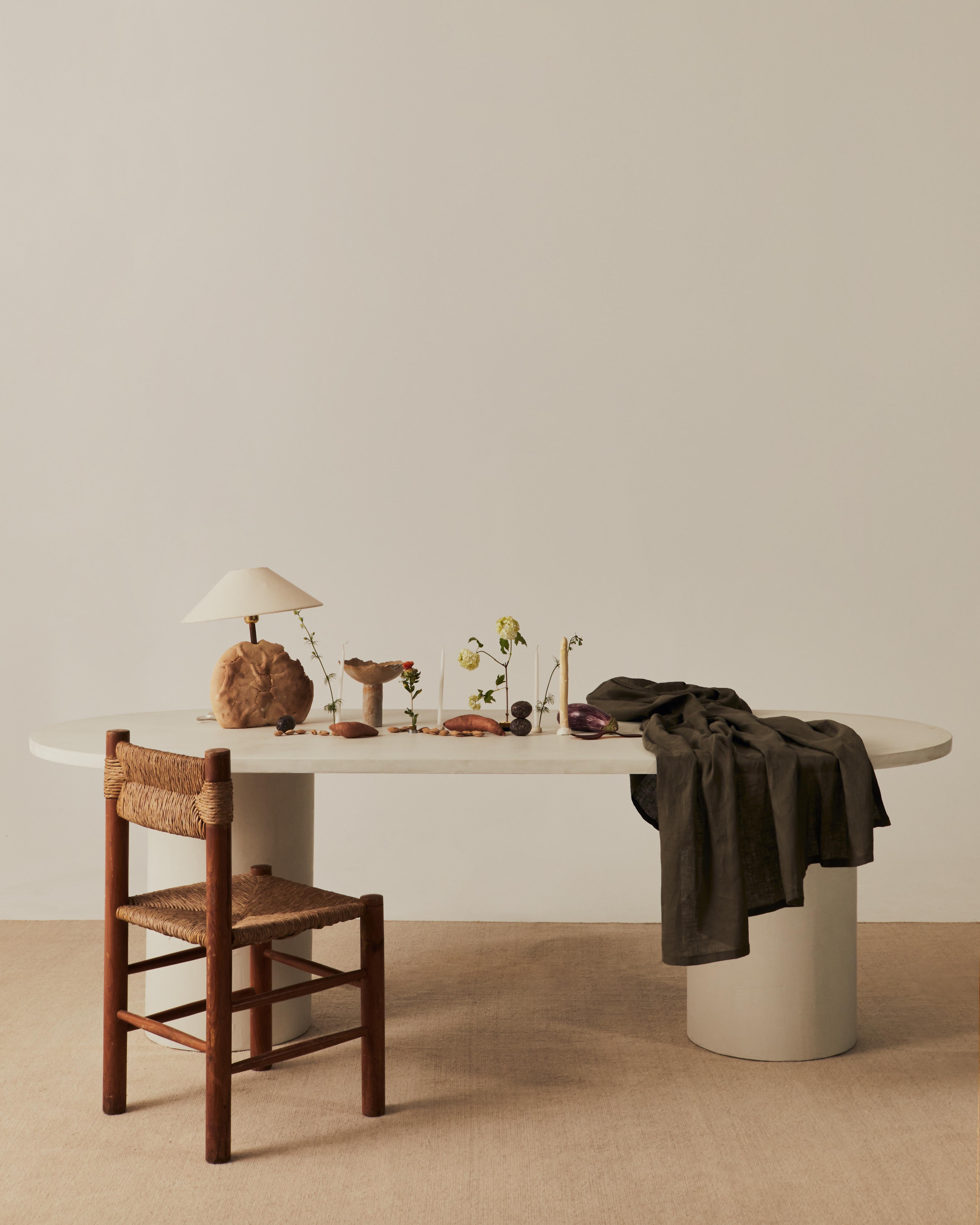 Handcrafted in Spain by expert artisans, this oval-shaped dining table from Marlot Baus combines timeless design with modern craftsmanship. Each piece is carefully made using our signature microcement technique, layered by hand to achieve a smooth,