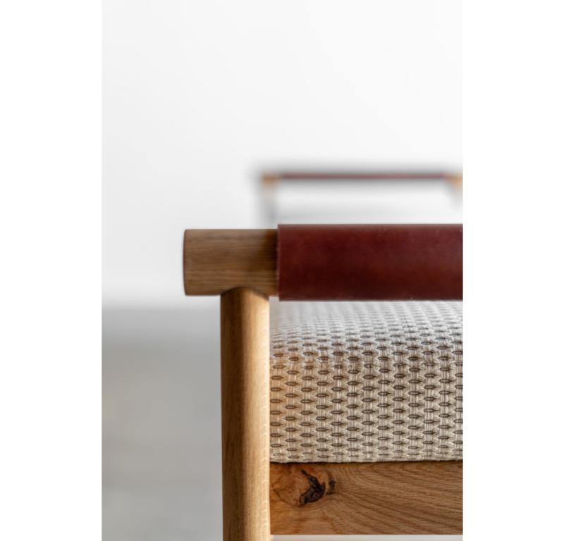 The Reyes Bench is handmade locally in Los Angeles, California. The solid wood oak frame is made of handmade dowels. The arms are wrapped with rich, chestnut vegetable tanned leather. The seat cushion is finished in a performance home fabric.