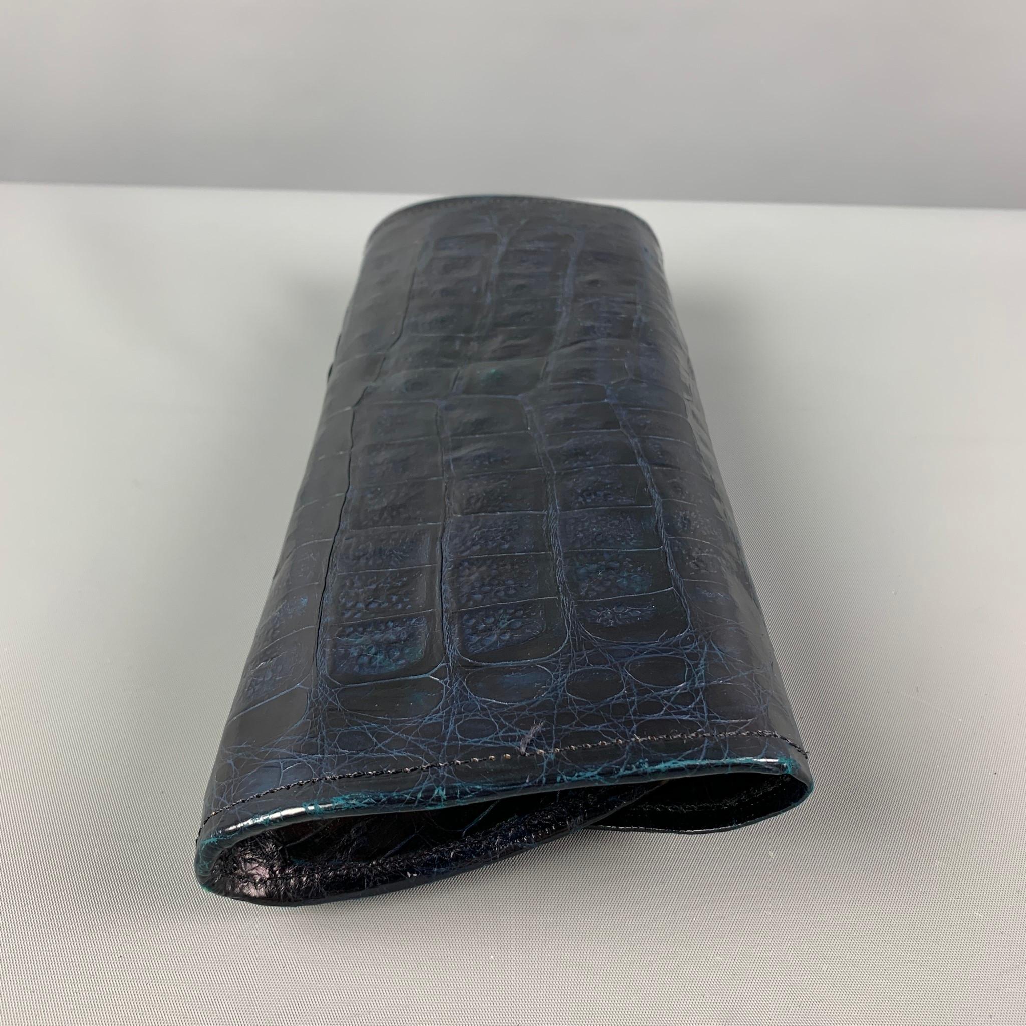 REYNA ICAZA 'Camden' clutch comes in a black alligator leather featuring a front flap, inner slot, and a magnetic closure. 

Very Good Pre-Owned Condition.

Measurements:

Length: 11 in.
Width: 1.5 in.
Height: 5 in. 