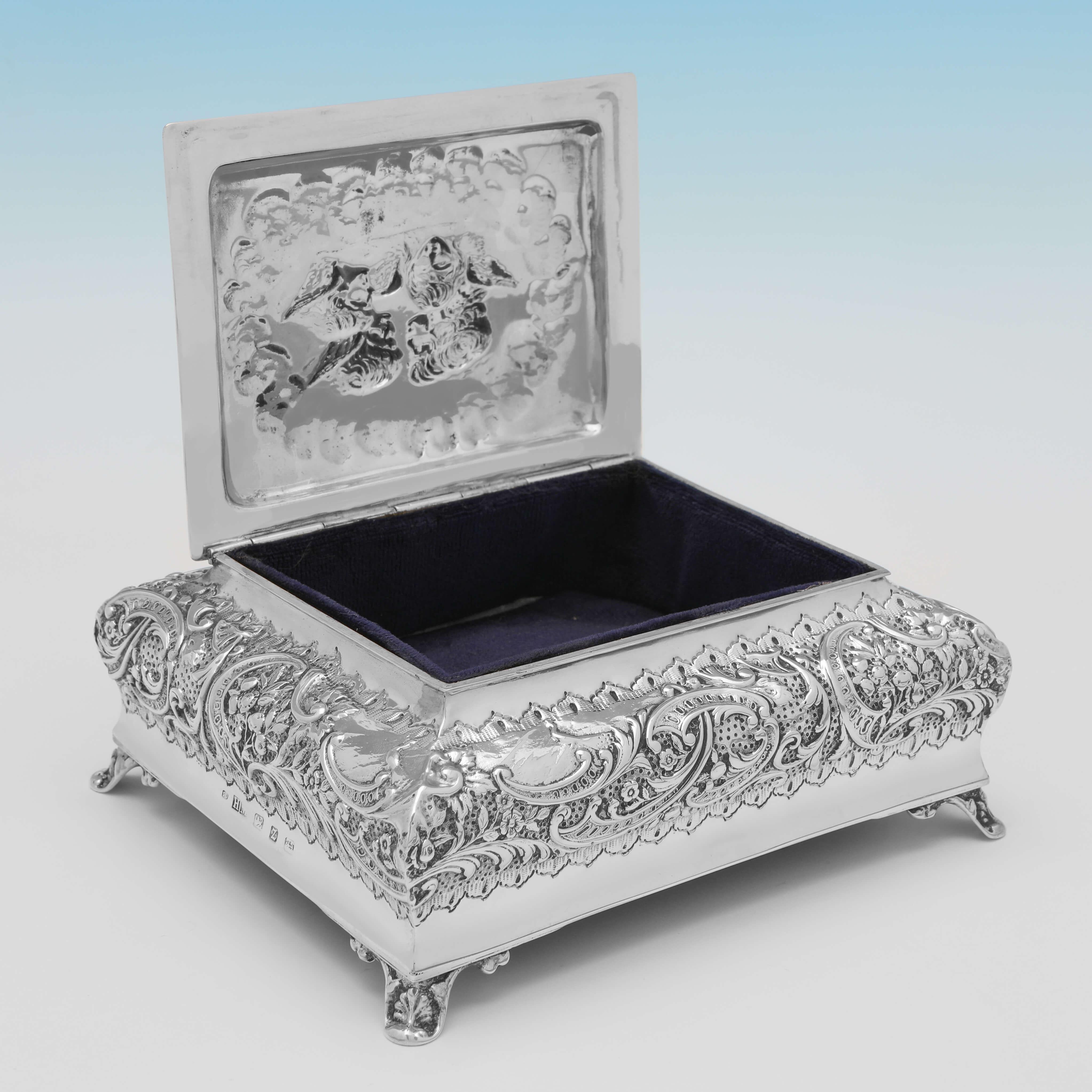 Hallmarked in Birmingham in 1899 by Henry Matthews, this attractive, Victorian, Antique, Sterling Silver Jewellery Box, is lined, and features ornate decoration to the sides, and a representation of the 'Reynolds Angels' on the lid. 

The
